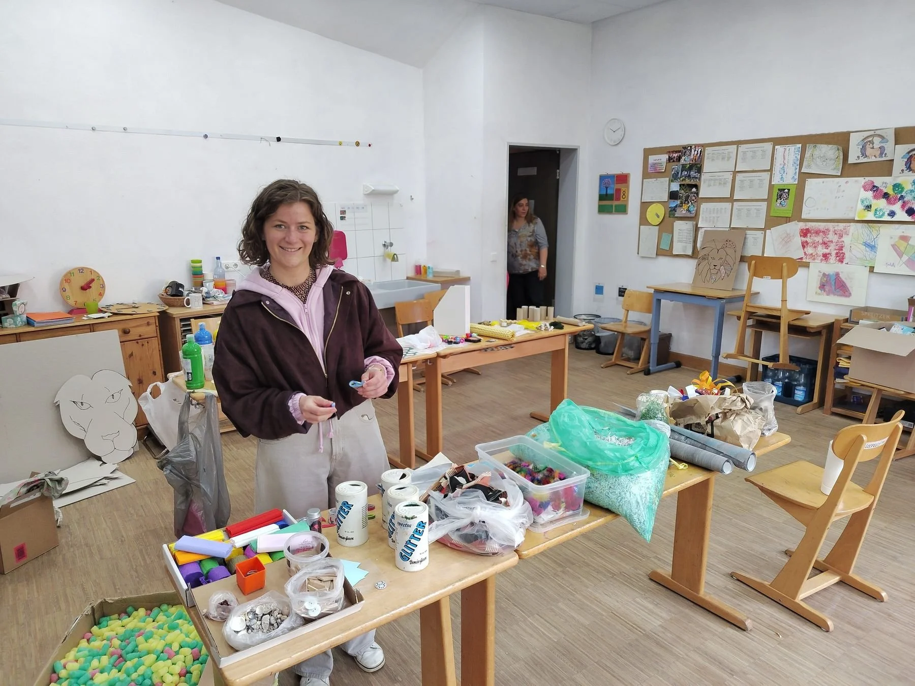 Künstlerin erklärt den Teilnehmenden Materialien und Ablauf des Kunstkurses.
