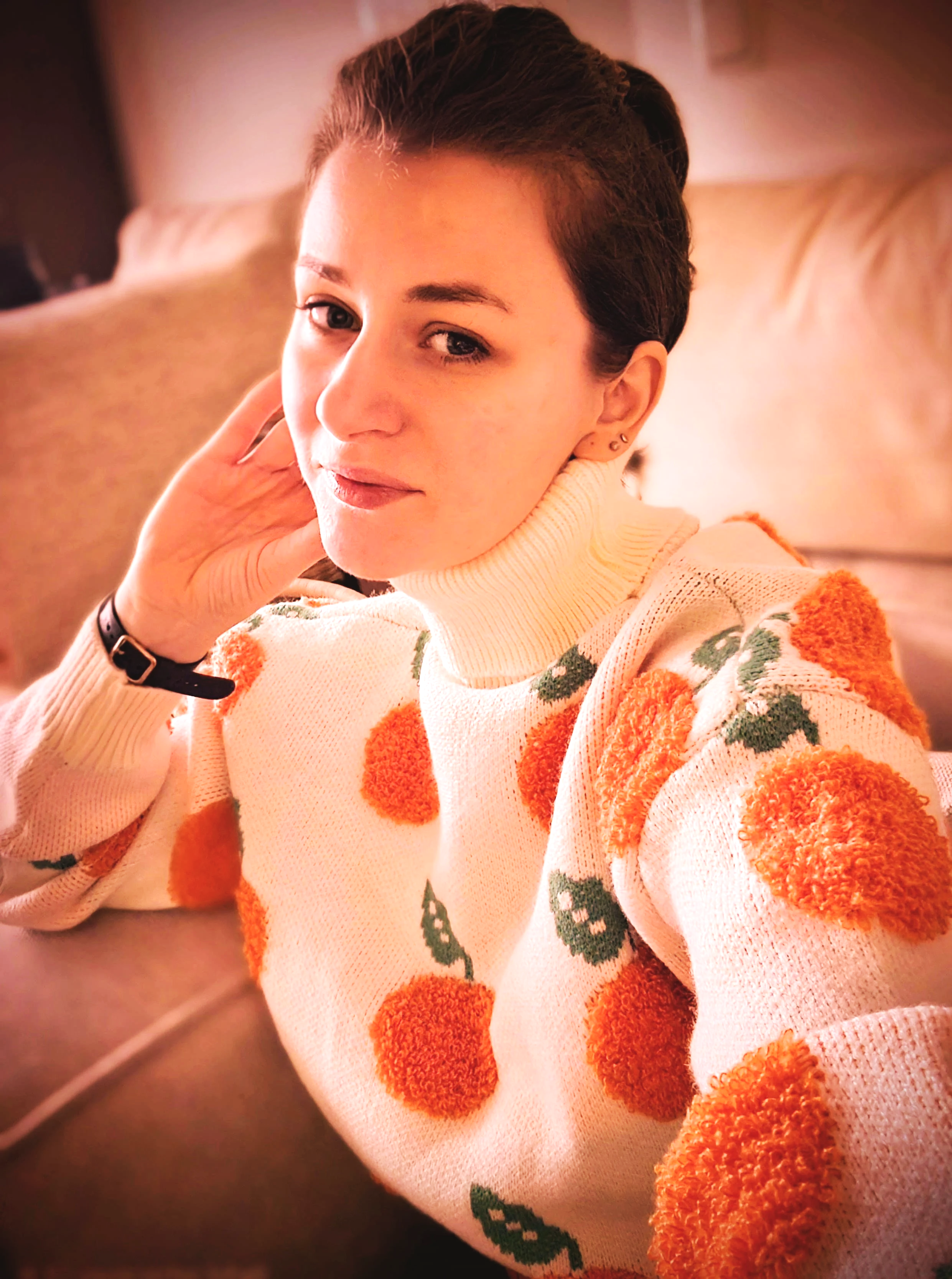 Portrait der Portraitkünstlerin Nadine Schuhmann. Sie trägt einen weißen Pullover mit Orangenmotiv, das die Farbwelt und Identität von Atelier mandarange aufgreift.