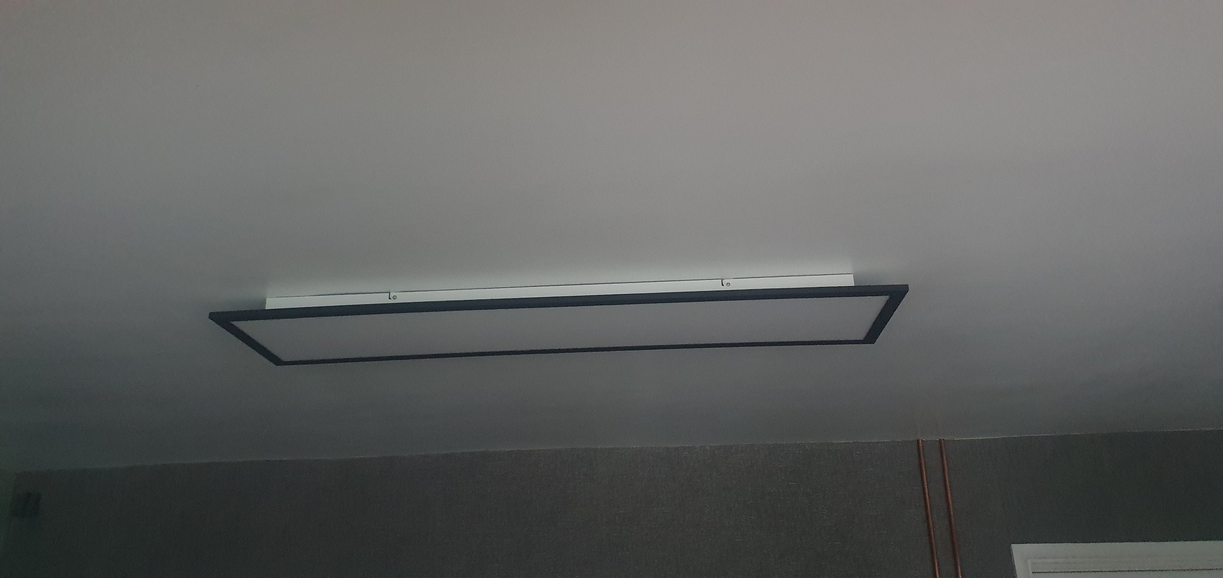 A rectangular ceiling light fixture with a black frame, mounted on a white ceiling.