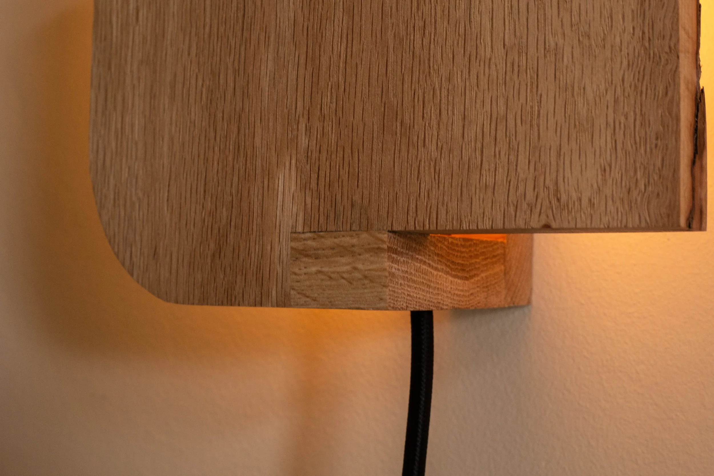 Handcrafted oak wall sconce with frosted glass diffuser. A minimalist designer light for luxury interiors and design-led homes.