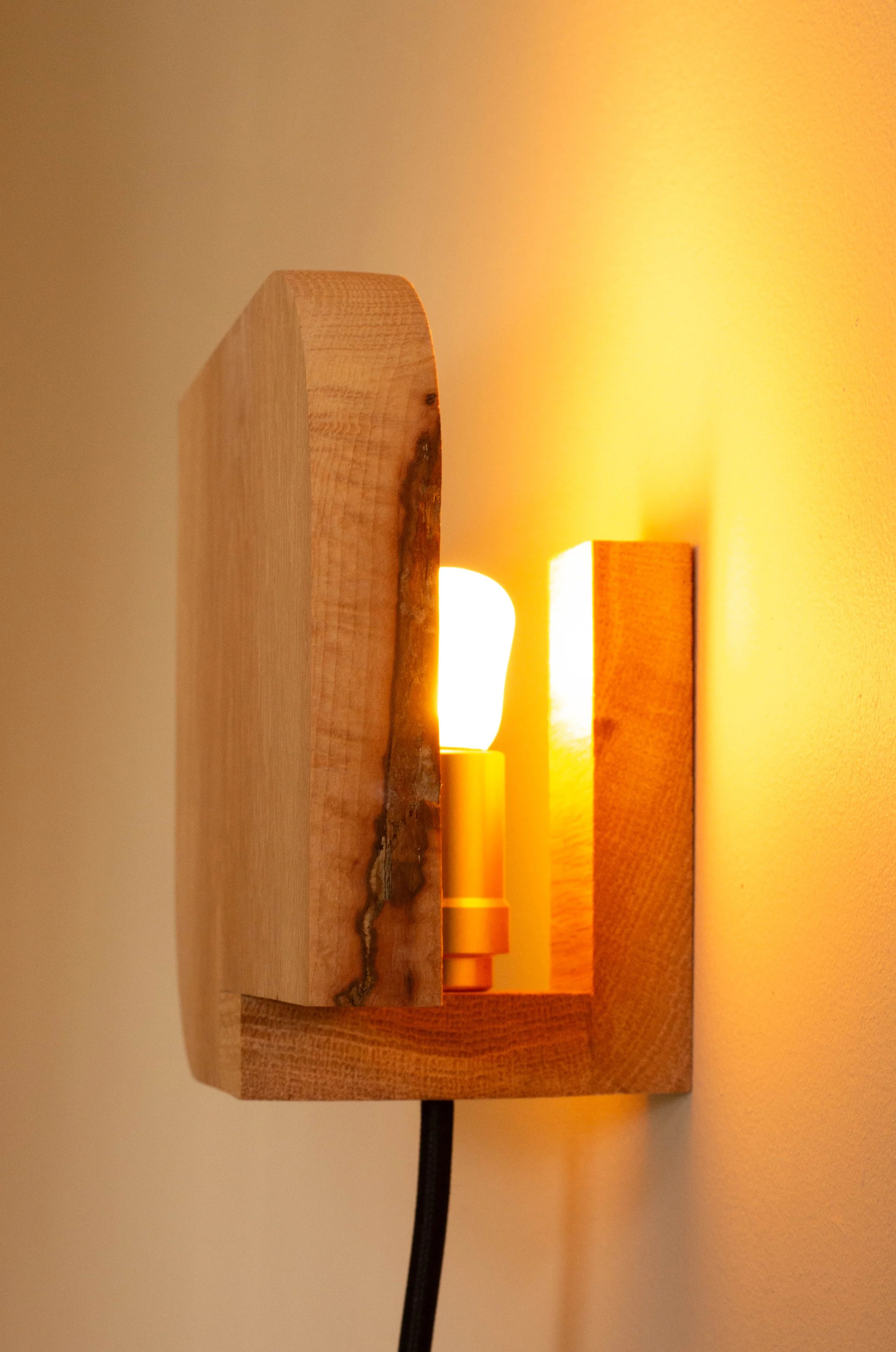 Modern wall sconce in solid oak with frosted glass. Contemporary designer lighting for living rooms, bedrooms, and high-end interiors.