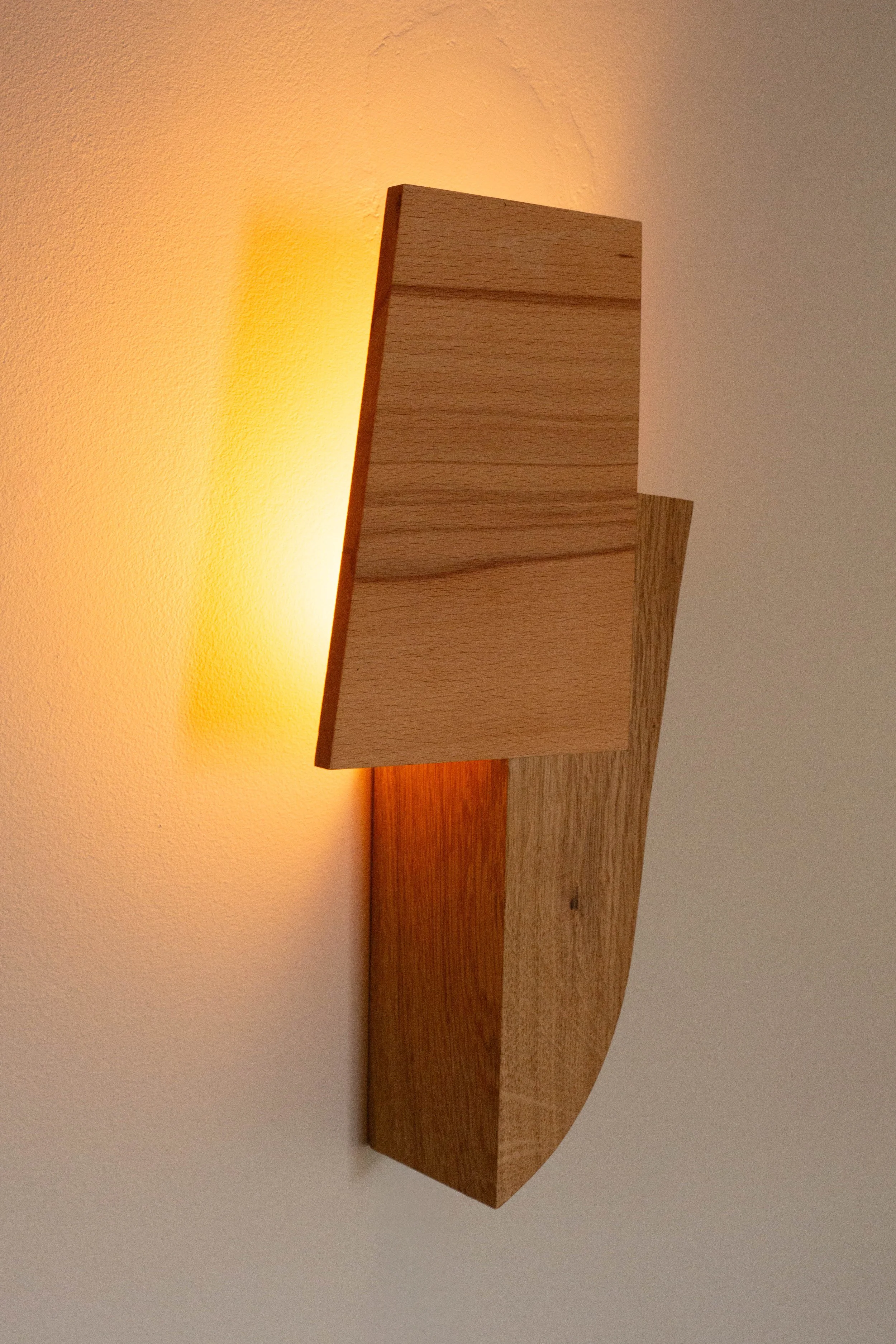 Sculptural hardwood wall light, warm ambient glow