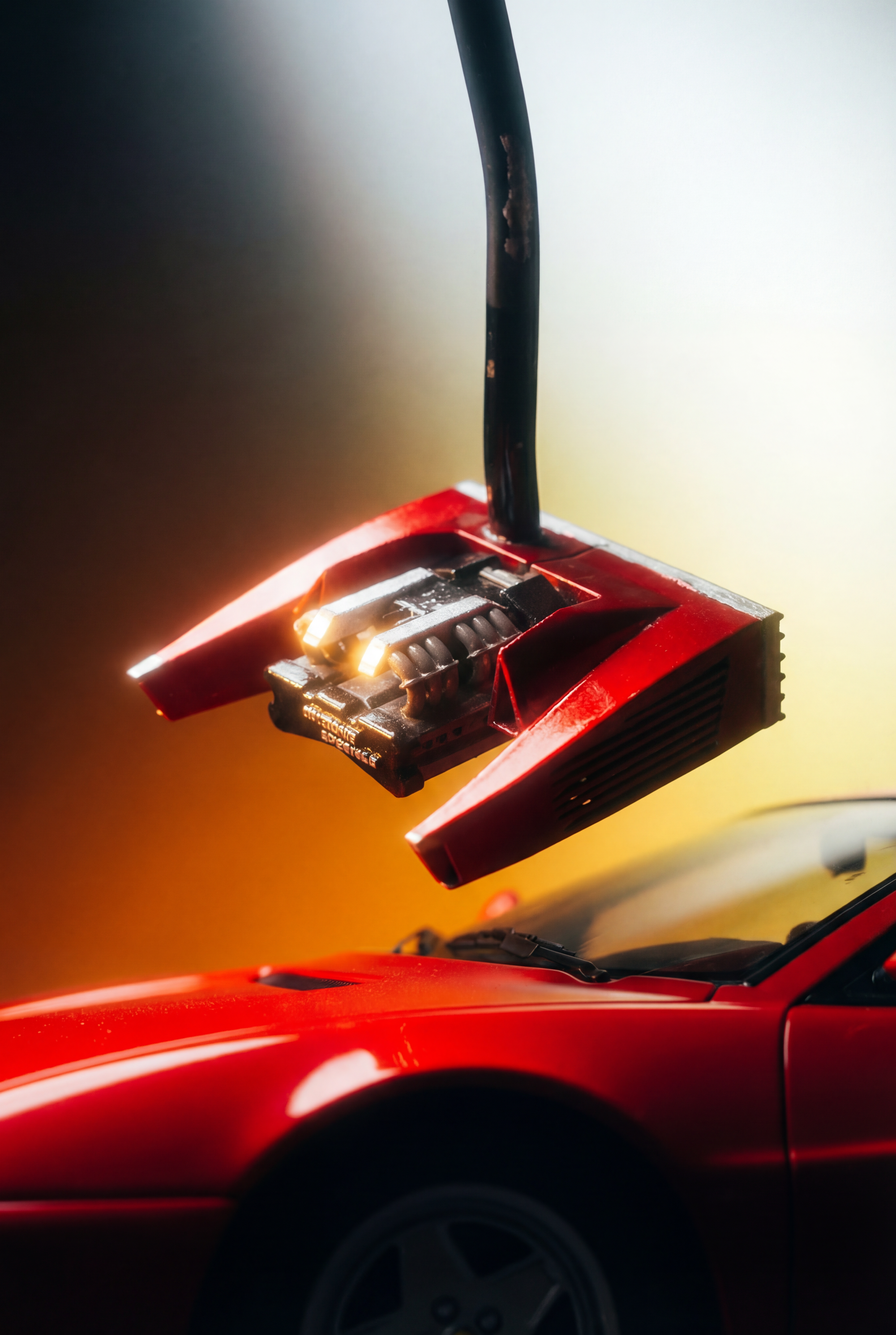 Close-up of a red sports car with a futuristic putter above its hood, featuring glowing yellow lights and black details, with a gradient blurred background.