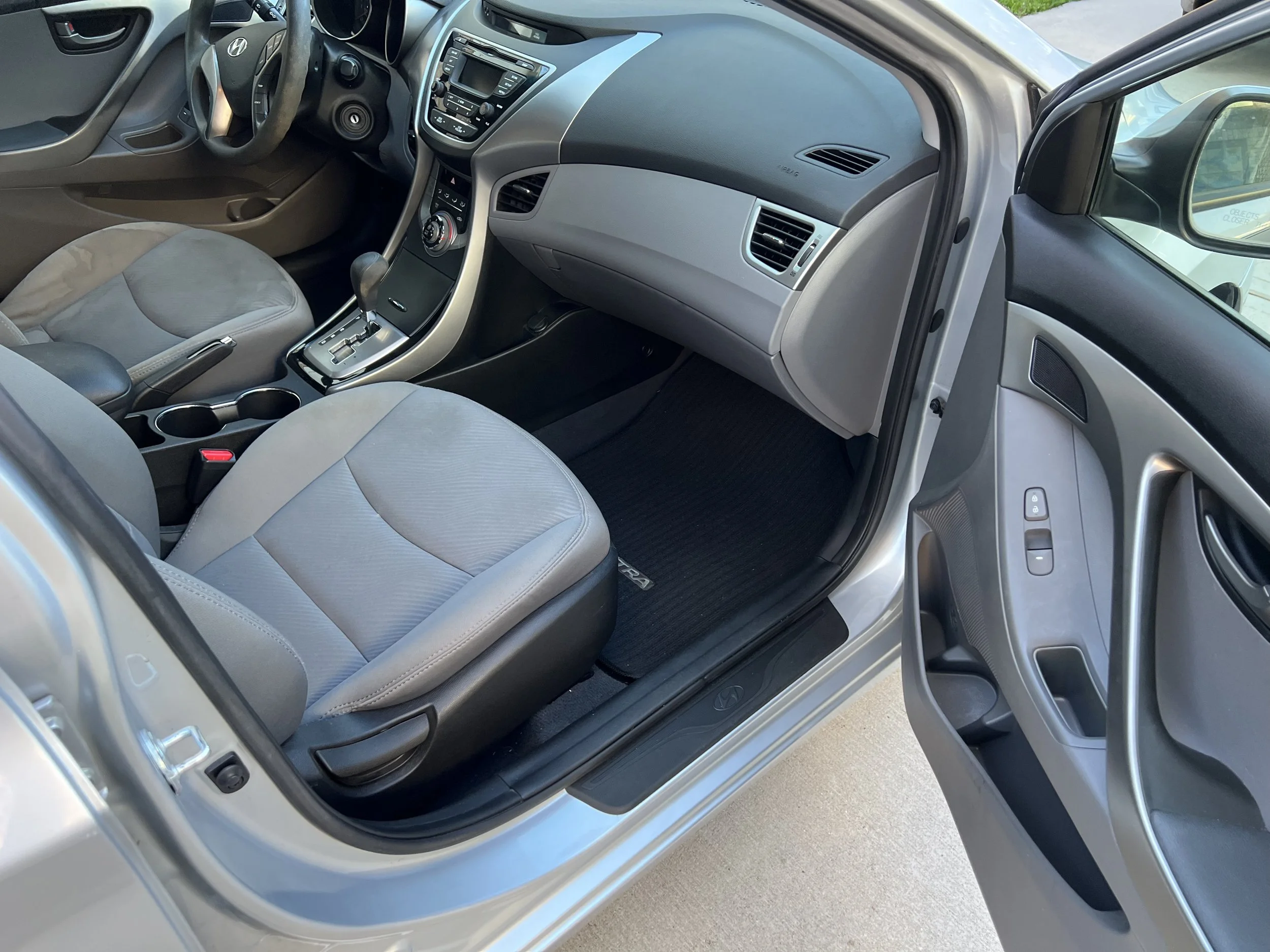 Interior of a silver Hyundai car showing front passenger seat, dashboard, center console, and door panel.