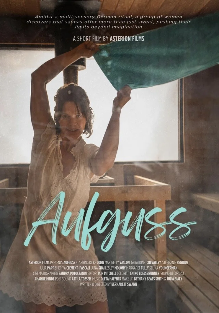 A woman inside a sauna, smiling and lifting a green towel, with the sauna's glass door visible. The image is promotional for a short film titled 'Aufguss'.