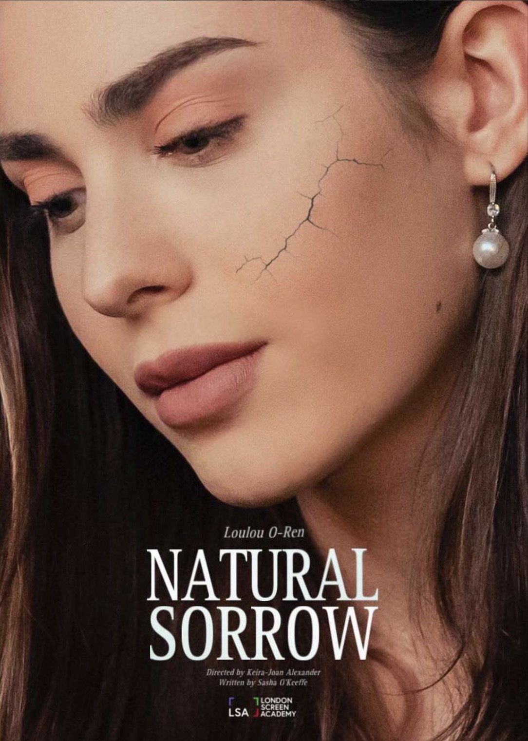 Close-up of a woman's face with a prominent crack running down her cheek. She has brown hair, makeup, and is wearing a pearl earring. The image has text overlay: 'Loulou O-Ren, Natural Sorrow, directed by Keira-Joan Alexander, written by Sasha O'Keefe, London Screen Academy.'