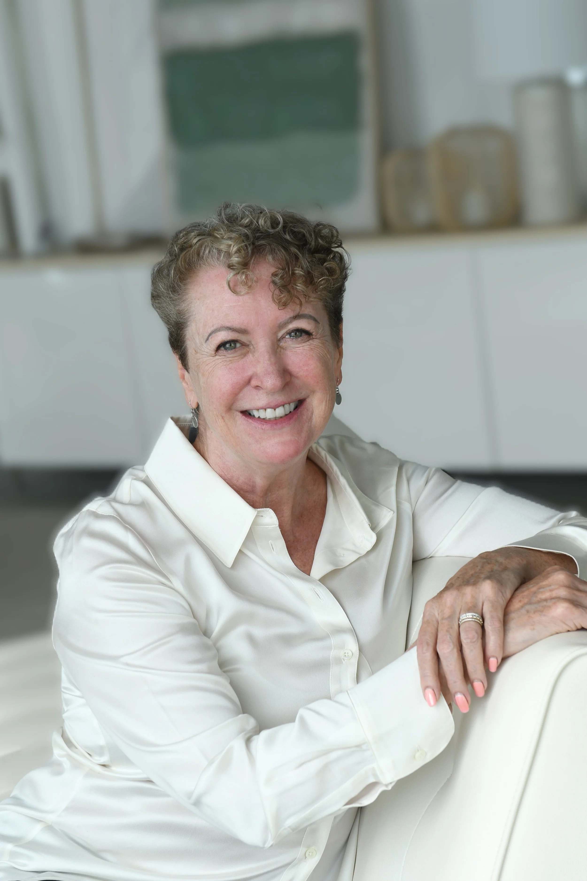 Joy Hunter Leaning on a Sofa Blurred Background