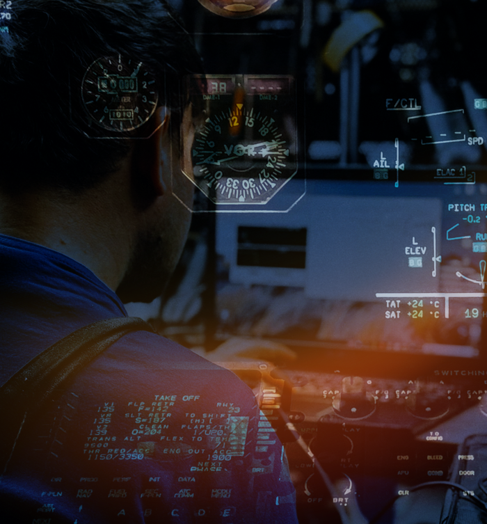 A pilot looking at a helicopter cockpit with digital and analog flight instruments and controls.