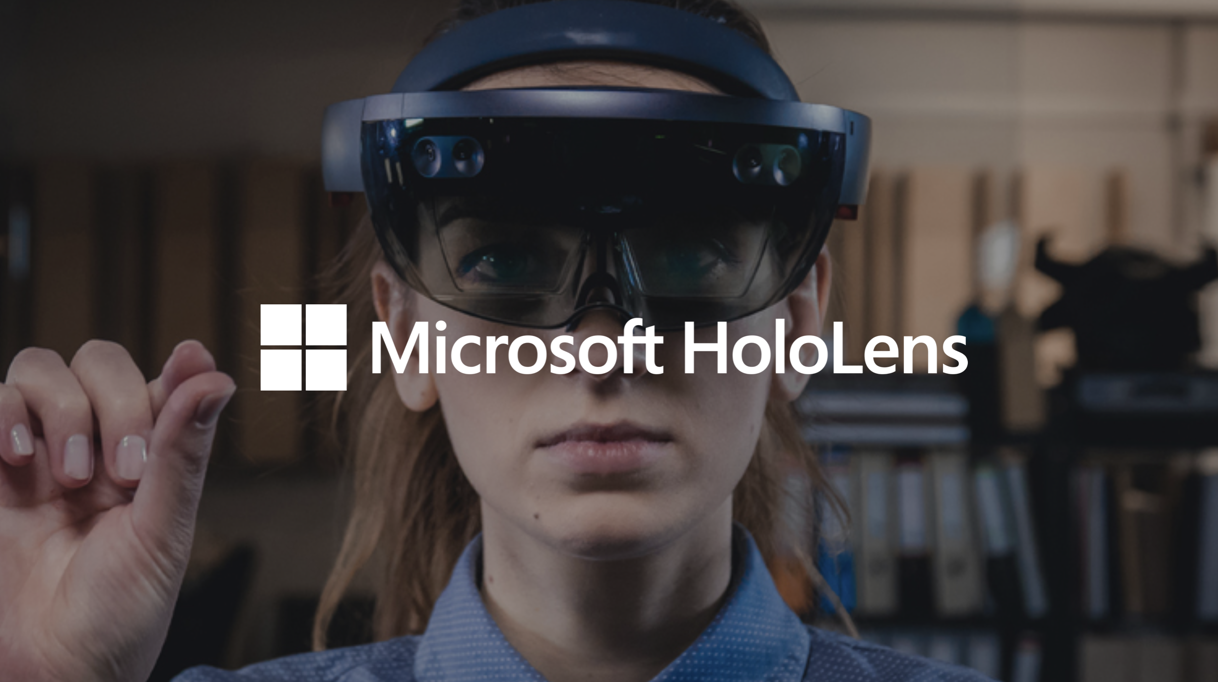 A woman wearing augmented reality glasses in an office setting with bookshelves in the background, accompanied by the Microsoft HoloLens logo.