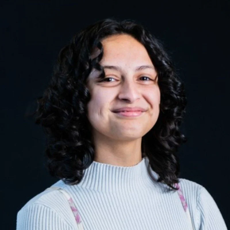 Headshot of Lilly Harryman. She wears a white ribbed turtleneck.