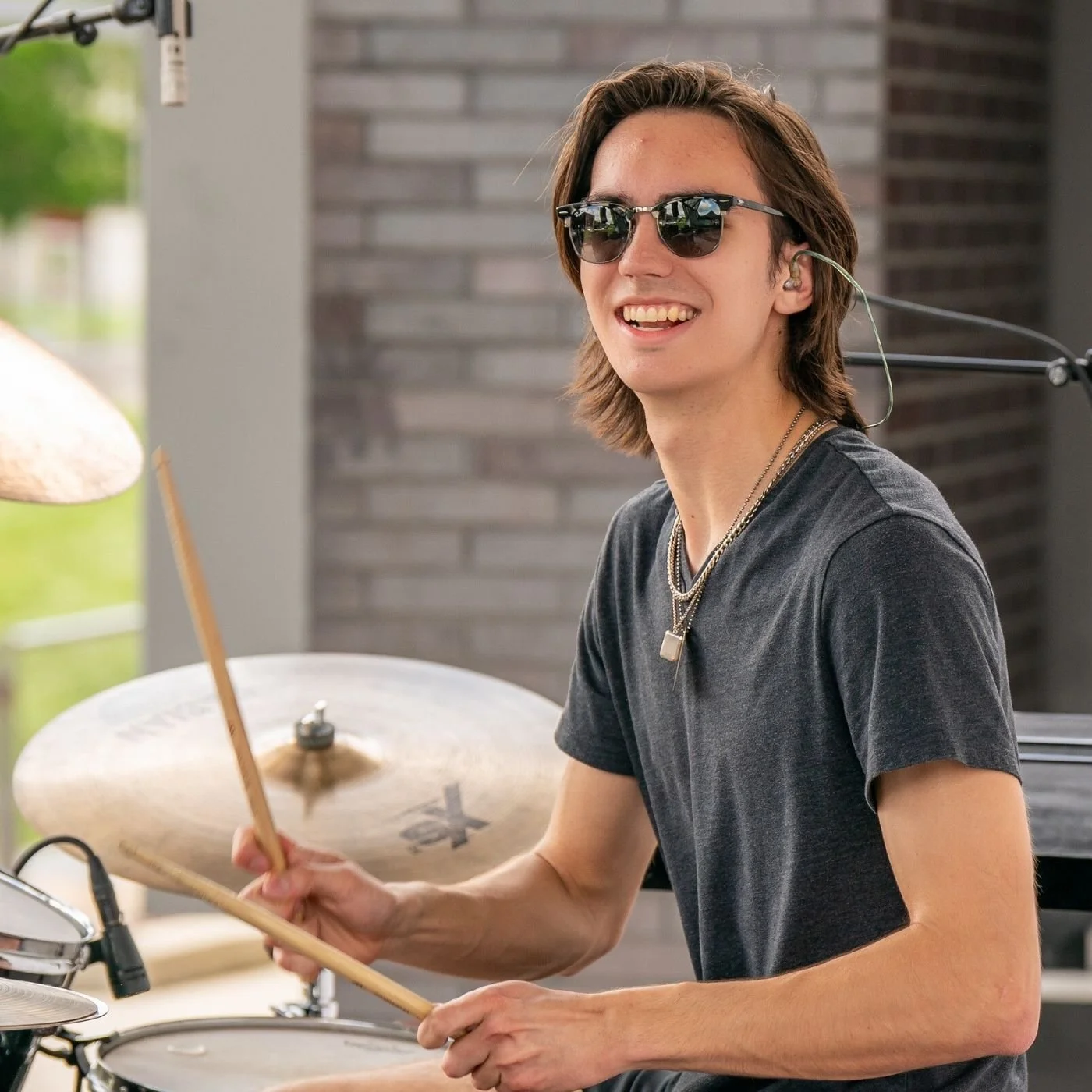 Photo of Garrett McKenzie. He is wearing a dark gray t-shirt and minimalist necklaces.