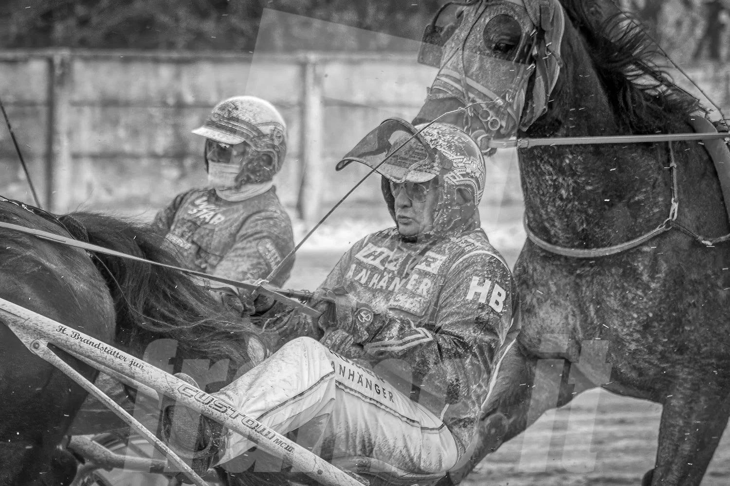 Trabrennfahrer in Schwarz-Weiß, mit Staub und Schmutz auf den Fahrern und Pferden.