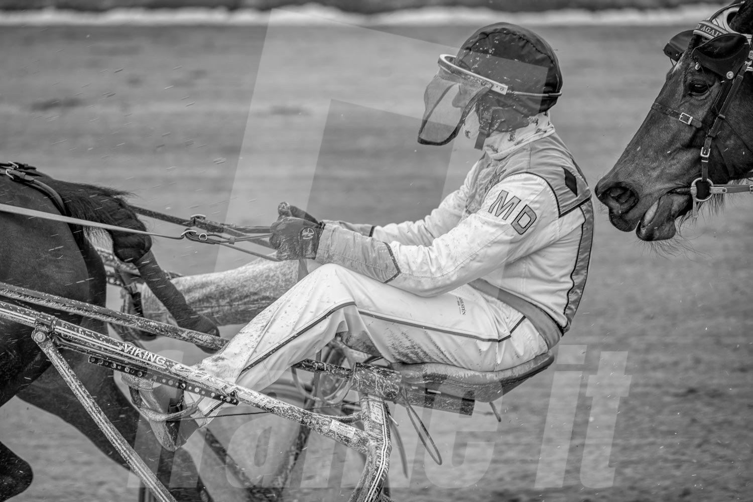 Pferderennfahrer mit Helm und Schutzbrille, im Schwarz-Weiß-Foto.