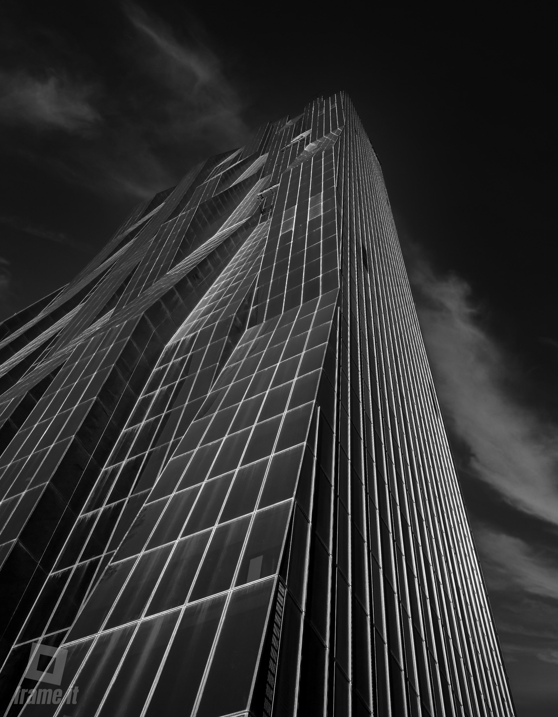 DC Tower Wien - Ein hoher, moderner Wolkenkratzer mit vielen Glasfenstern, aufgenommen aus einer tiefen Perspektive.