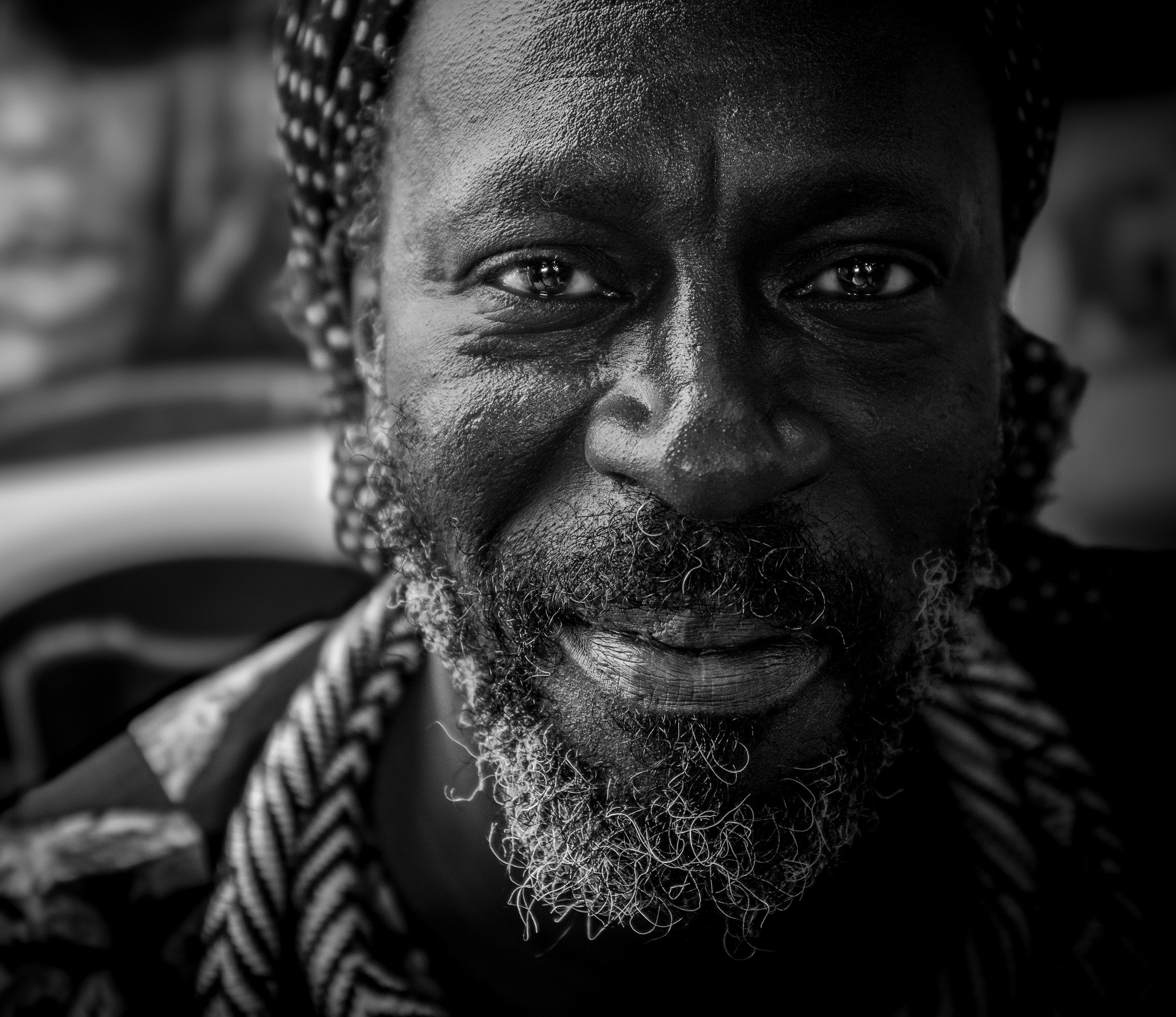 Schwarz-Weiß-Foto eines lächelnden älteren Mannes mit grauem Bart, aufgenommen bei den Afrika Tagen in Wien.