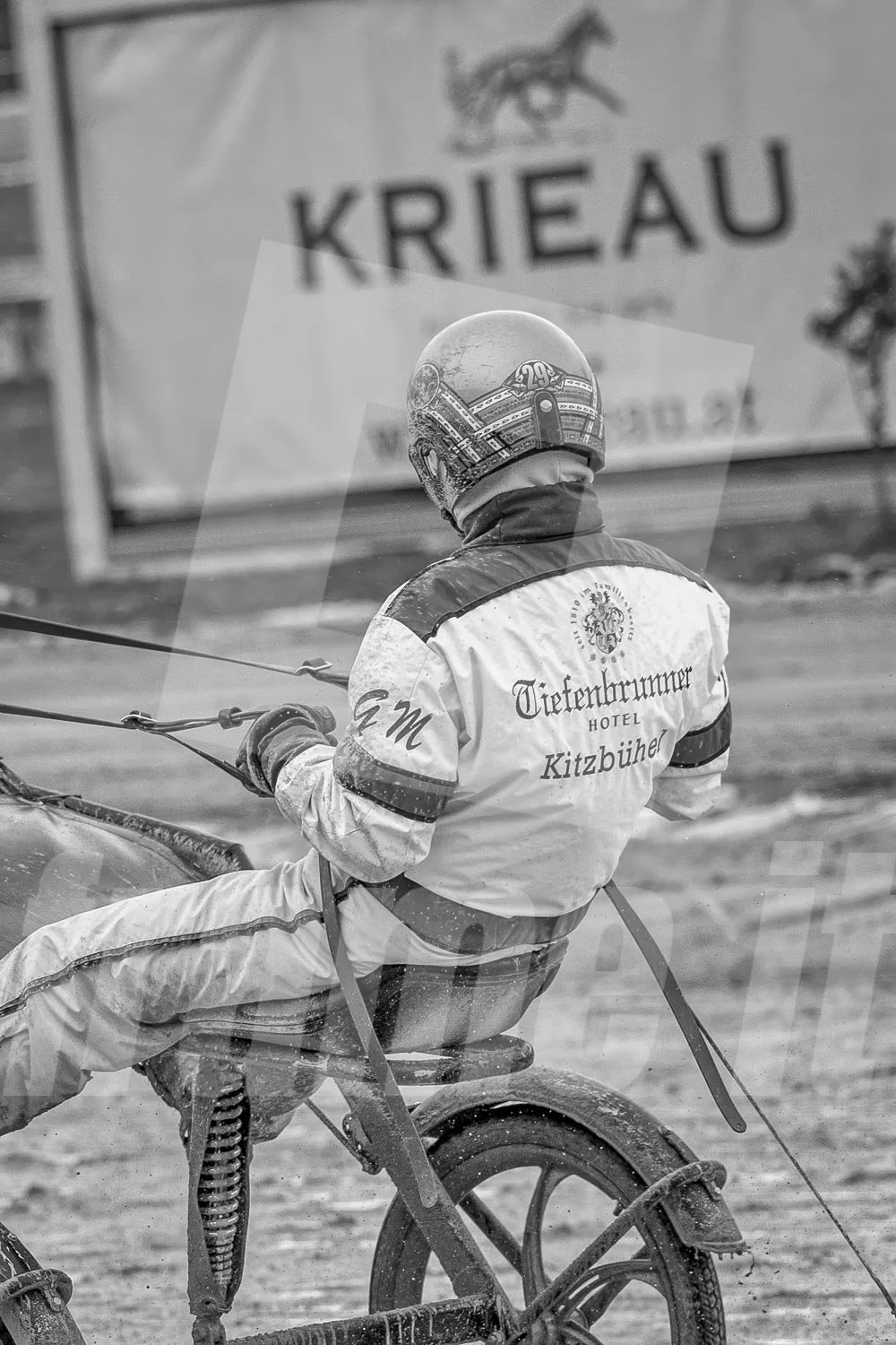 Schwarz-weiss Foto eines Trabrennpferdes, mit einem Trabrennfahrer, Gerhard Mayr, auf der Trabrennbahn in der Wiener Krieau.