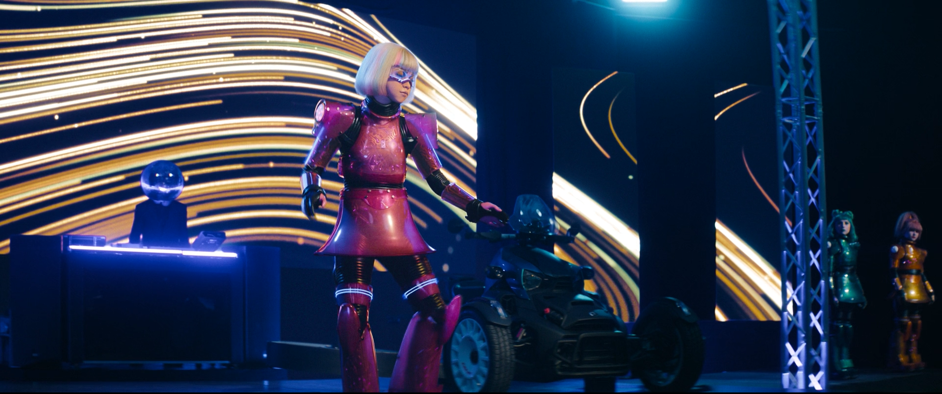 A person dressed in a futuristic pink and purple armor suit with a bob haircut and colorful glasses, standing next to a three-wheeled motorcycle on a stage with neon light streaks in the background.