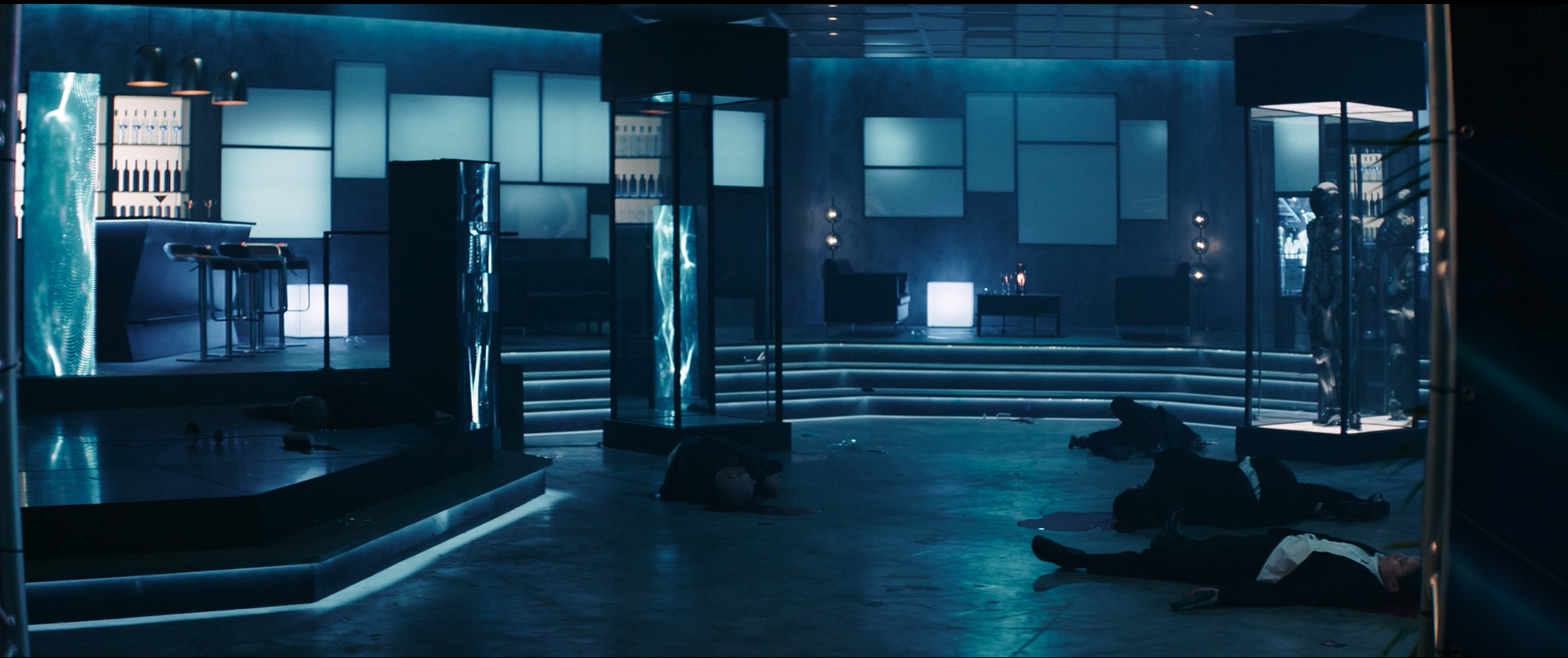 A dark, futuristic nightclub scene with a bar on the left, illuminated by blue lighting, and mannequins in glass cases on the right. Several bodies are sprawled on the floor, suggesting a violent event.