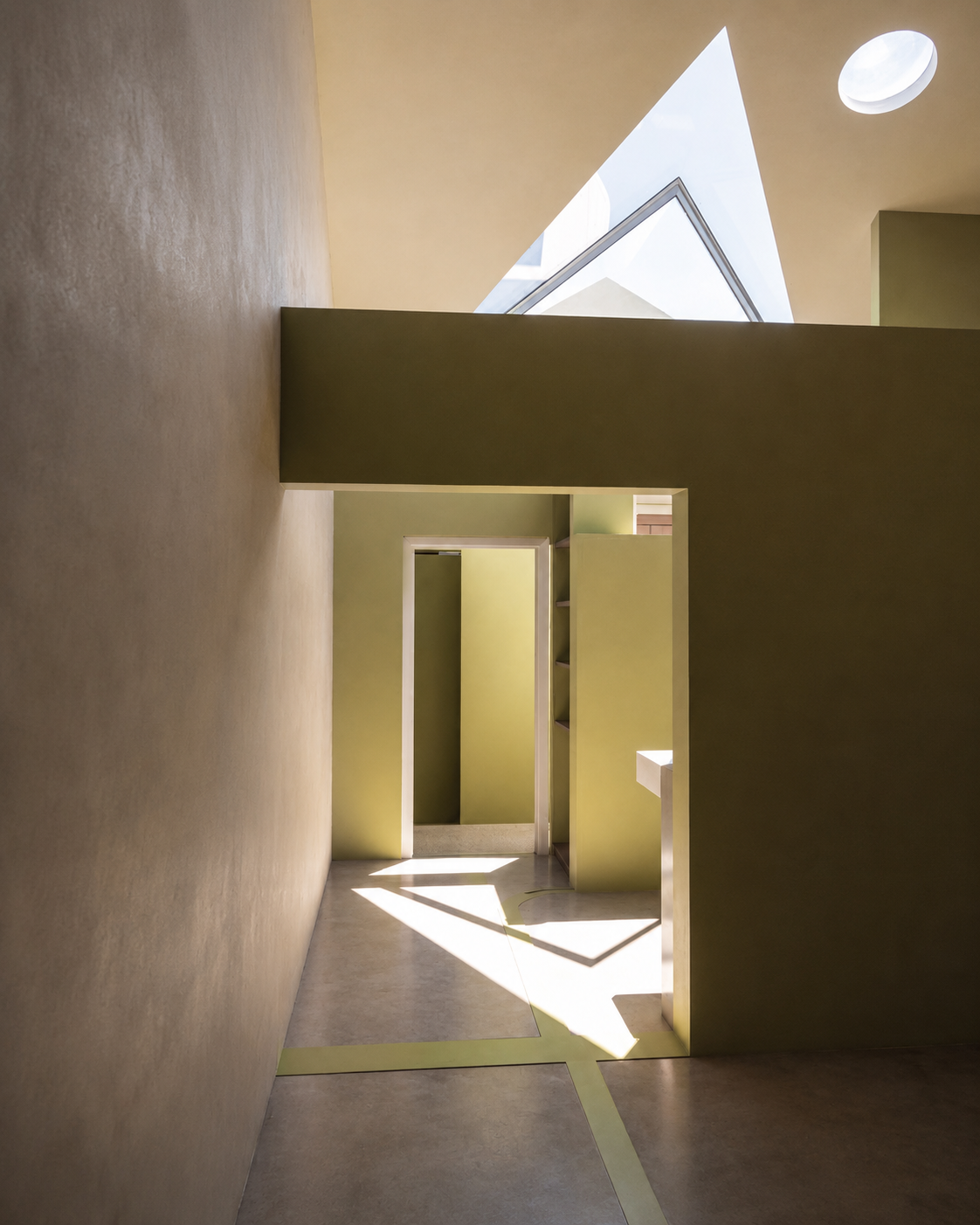 Surry Hills terrace renovation bedroom with skylit opening, green joinery and calm masonry surfaces.