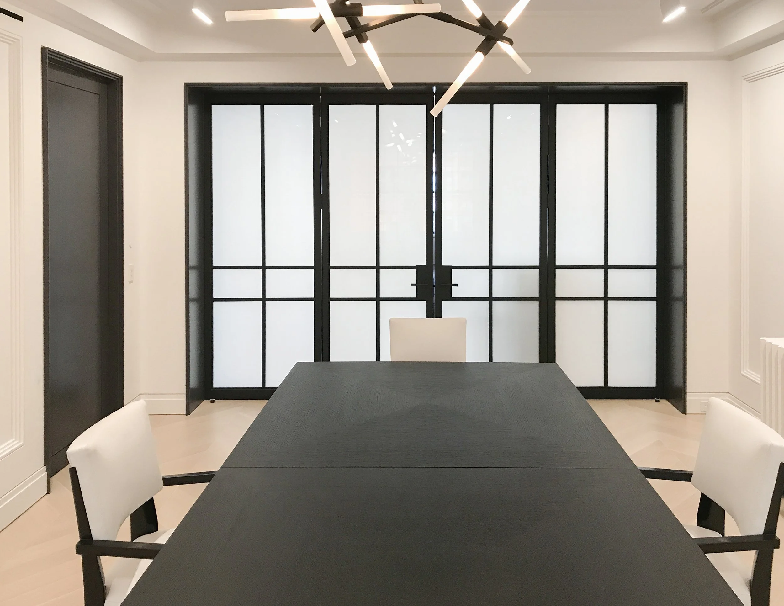 Custom-fabricated steel and glass doors for a private interior. The clean black steel framing gives the room a strong architectural character while keeping the space light and open.
