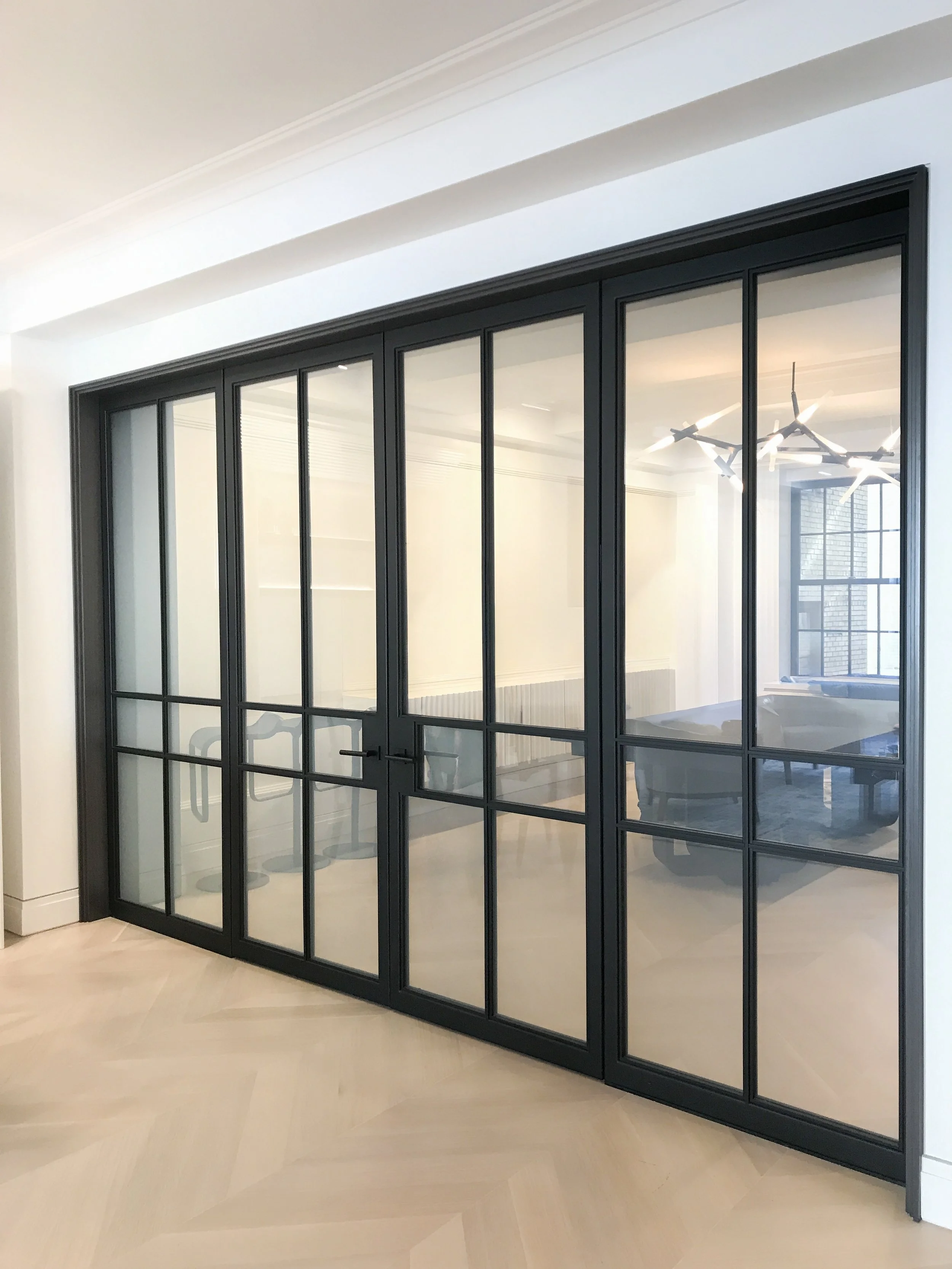 Custom-fabricated steel and glass doors for a private interior. The clean black steel framing gives the room a strong architectural character while keeping the space light and open.
