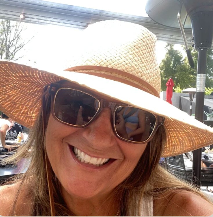 Woman, Michelle McDonagh, smiling with sunglasses and sunhat.
