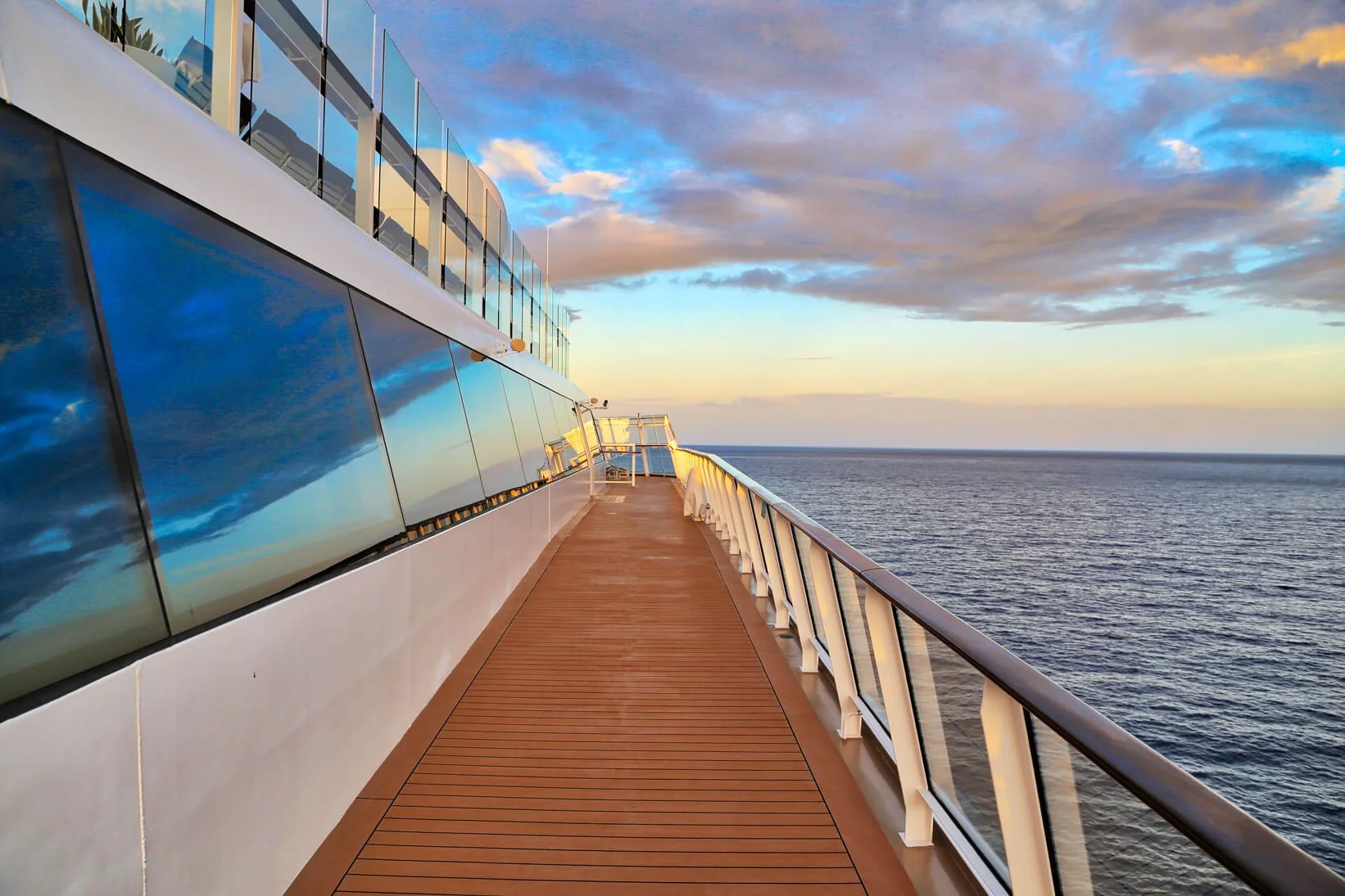Deck on a luxury cruise liner, with ocean and blue sky with clouds.