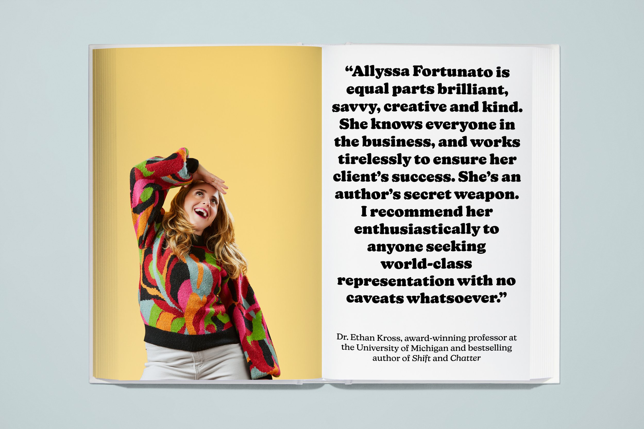 Open book with a page on the left showing a woman with long blonde hair wearing a colorful patterned sweater, smiling and holding her hand above her eyes as she looks up. The right page contains a quote about Allyssa Fortunato, praising her business 