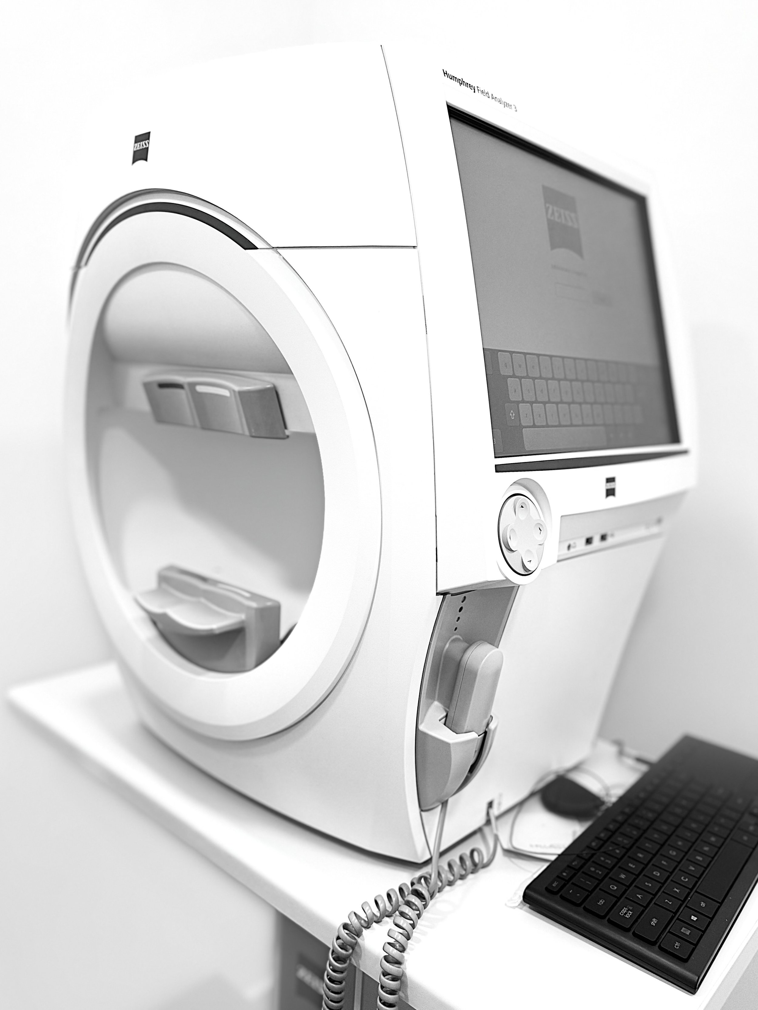 Medical testing machine with computer monitor and keyboard in a clinical setting.