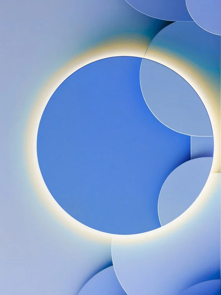 Abstract digital artwork featuring overlapping blue circles with glowing edges on a light blue background.