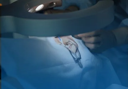 A medical procedure with a surgeon performing an operation using surgical instruments. The scene is in an operating room with sterile drapes.