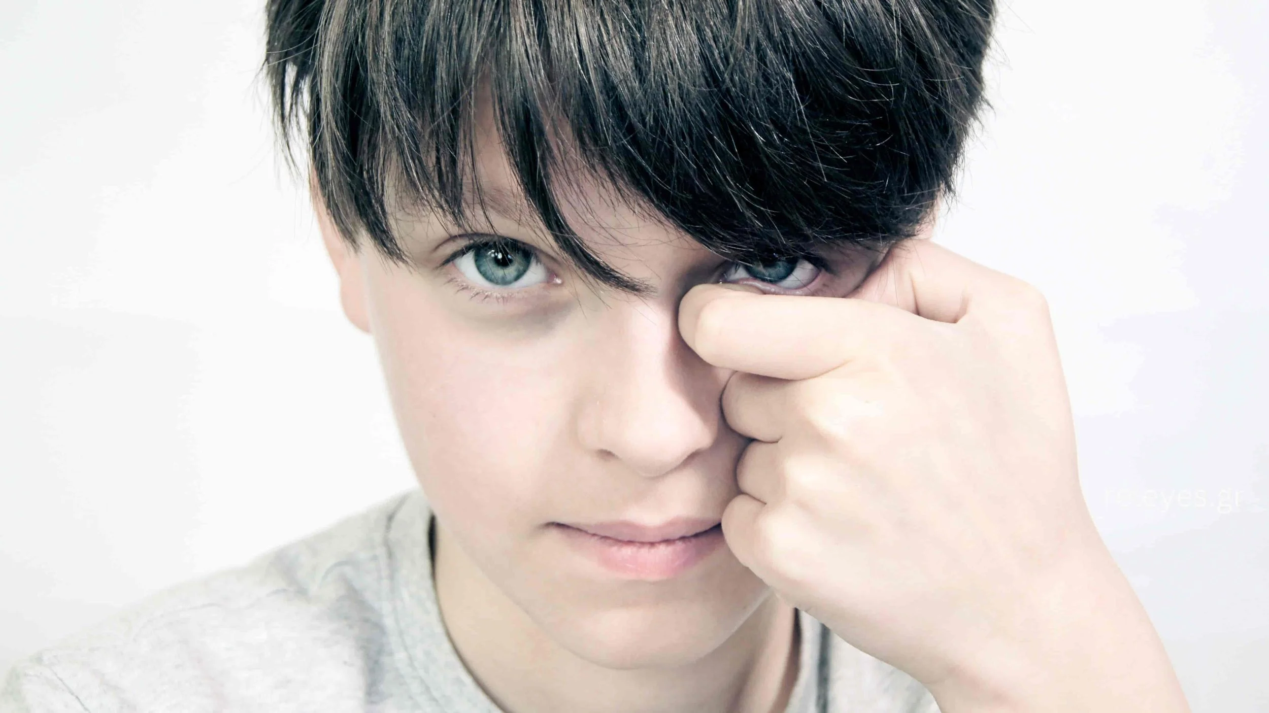 Παιδί που τρίβει το μάτι του, εικόνα που απεικονίζει το επιβλαβές τρίψιμο των ματιών ως παράγοντα κινδύνου για κερατόκωνο.