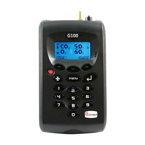 A handheld device with a blue backlit screen displaying CO2 and O2 levels. It has multiple buttons including a red power button, navigation buttons, and a numeric keypad. The device is labeled G100 and has a Geotech logo.