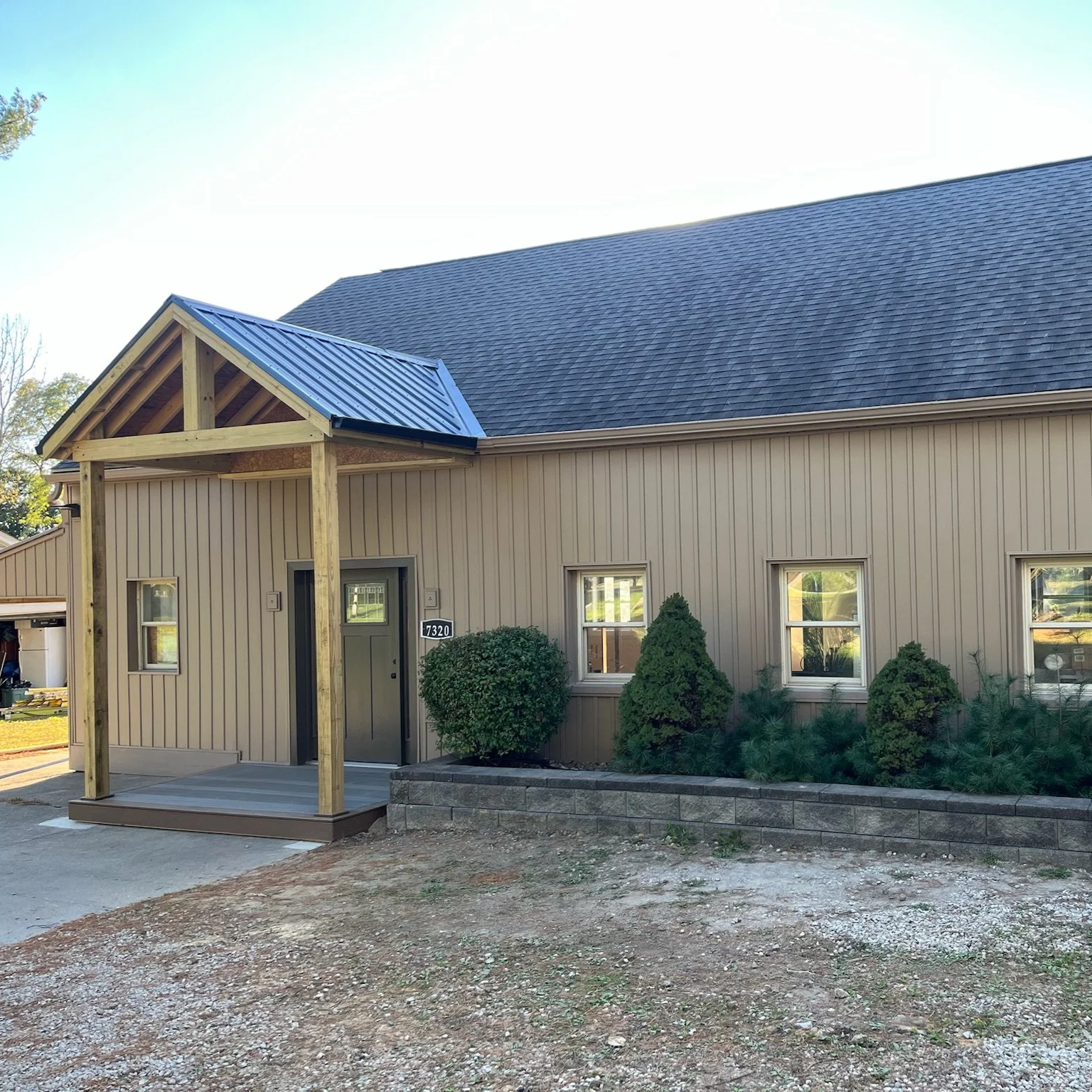 Front exterior of a house after new siding, a front door installation and addition of a new front porch.