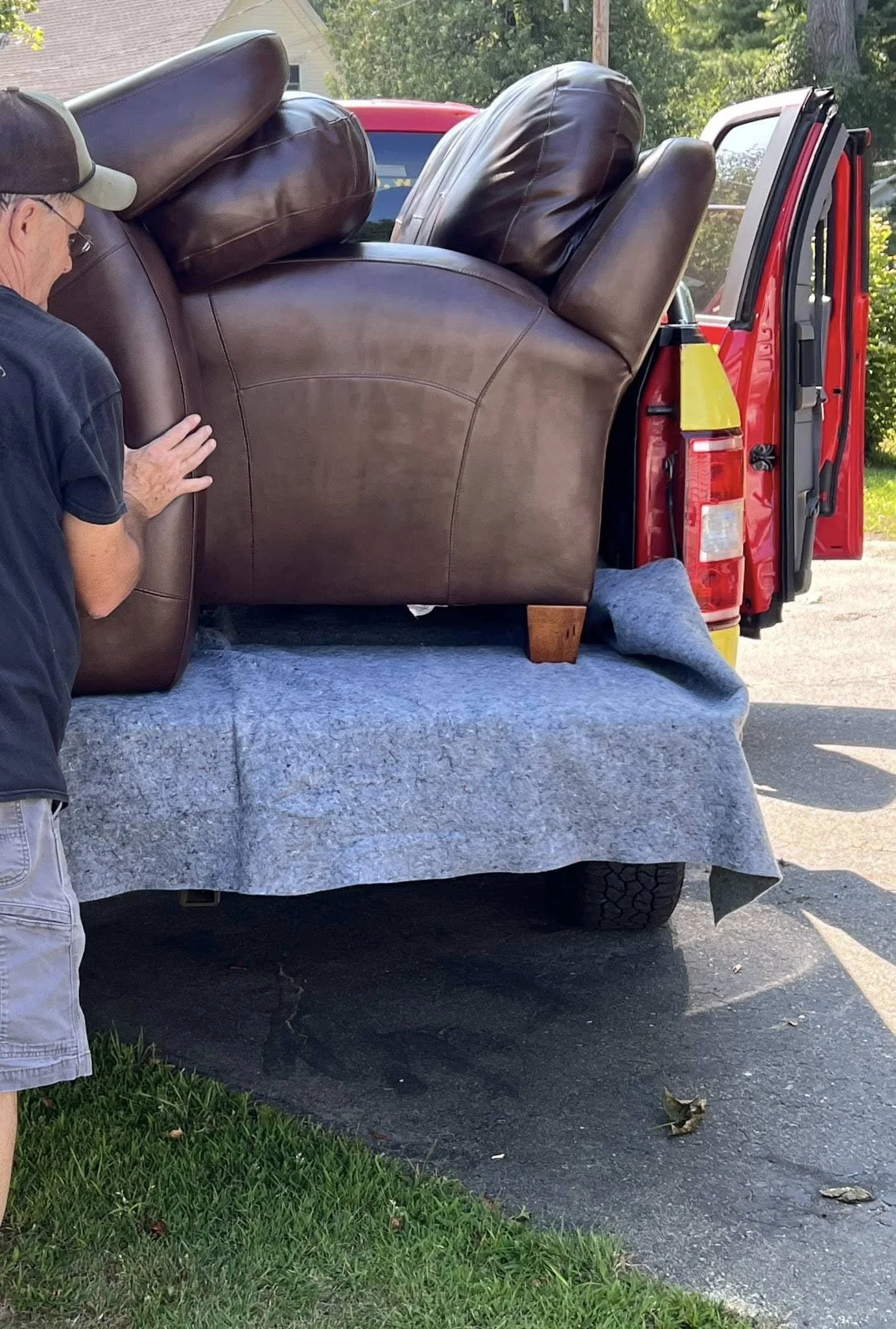 Oakland Furniture team loading a sofa for home delivery, showing careful handling and local delivery service in Central Maine.