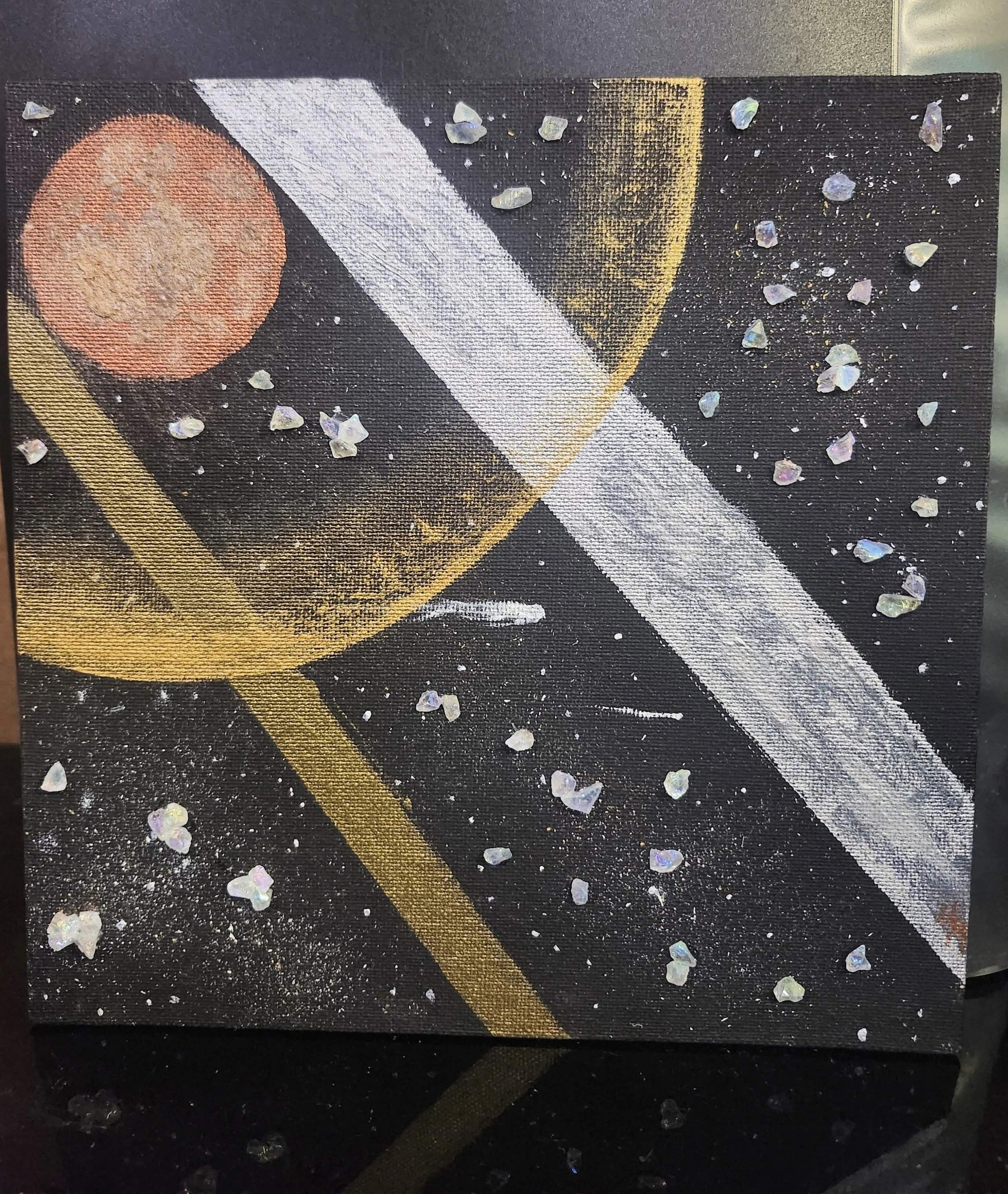 A small painting with plastic crystals hot glued on