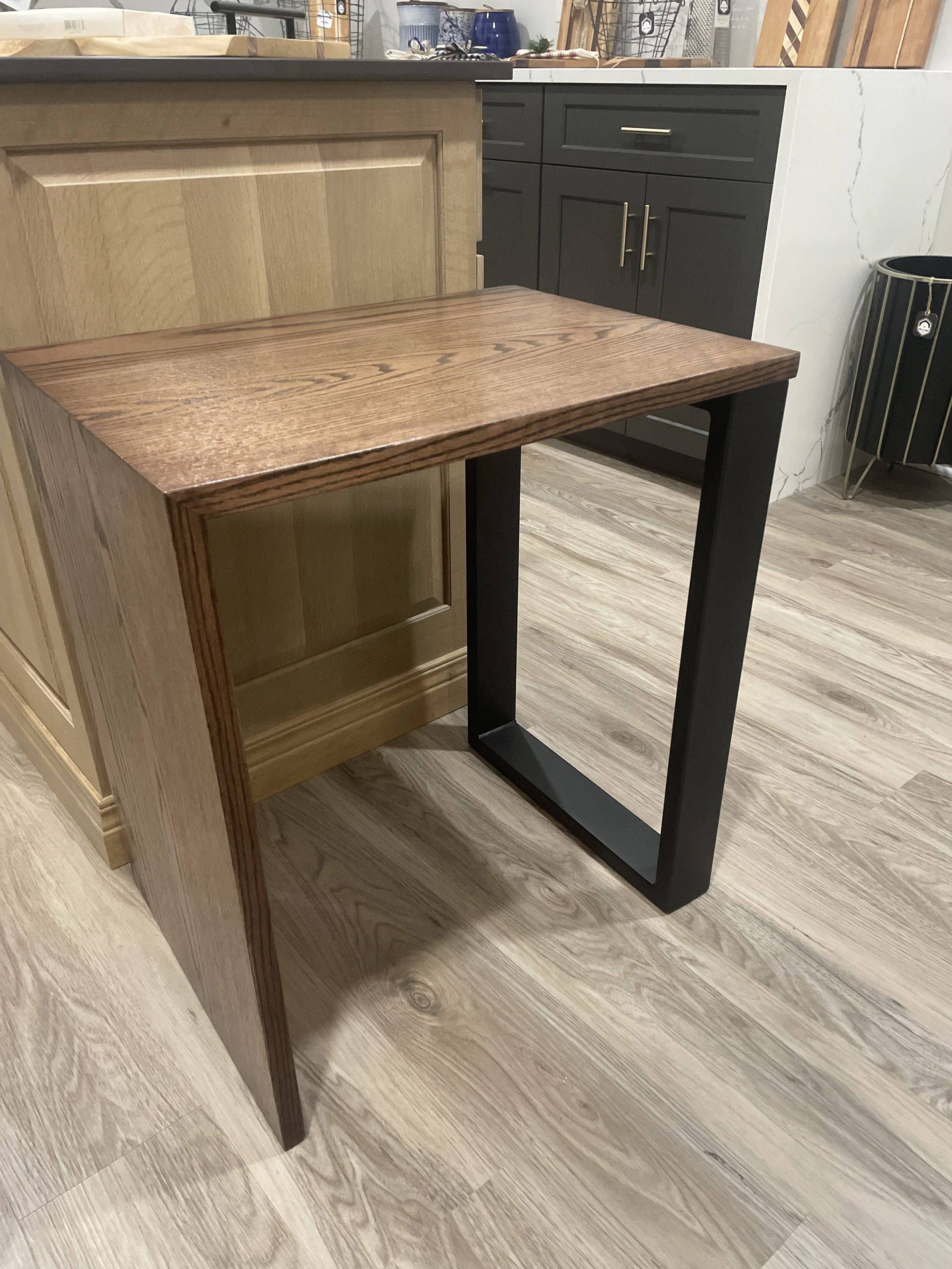 A modern wooden table with black metal legs in a furniture store.