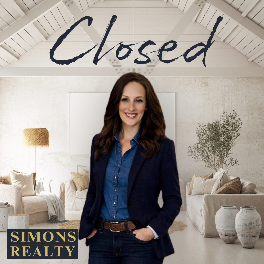 A woman with long brown hair wearing a blue coat  standing .