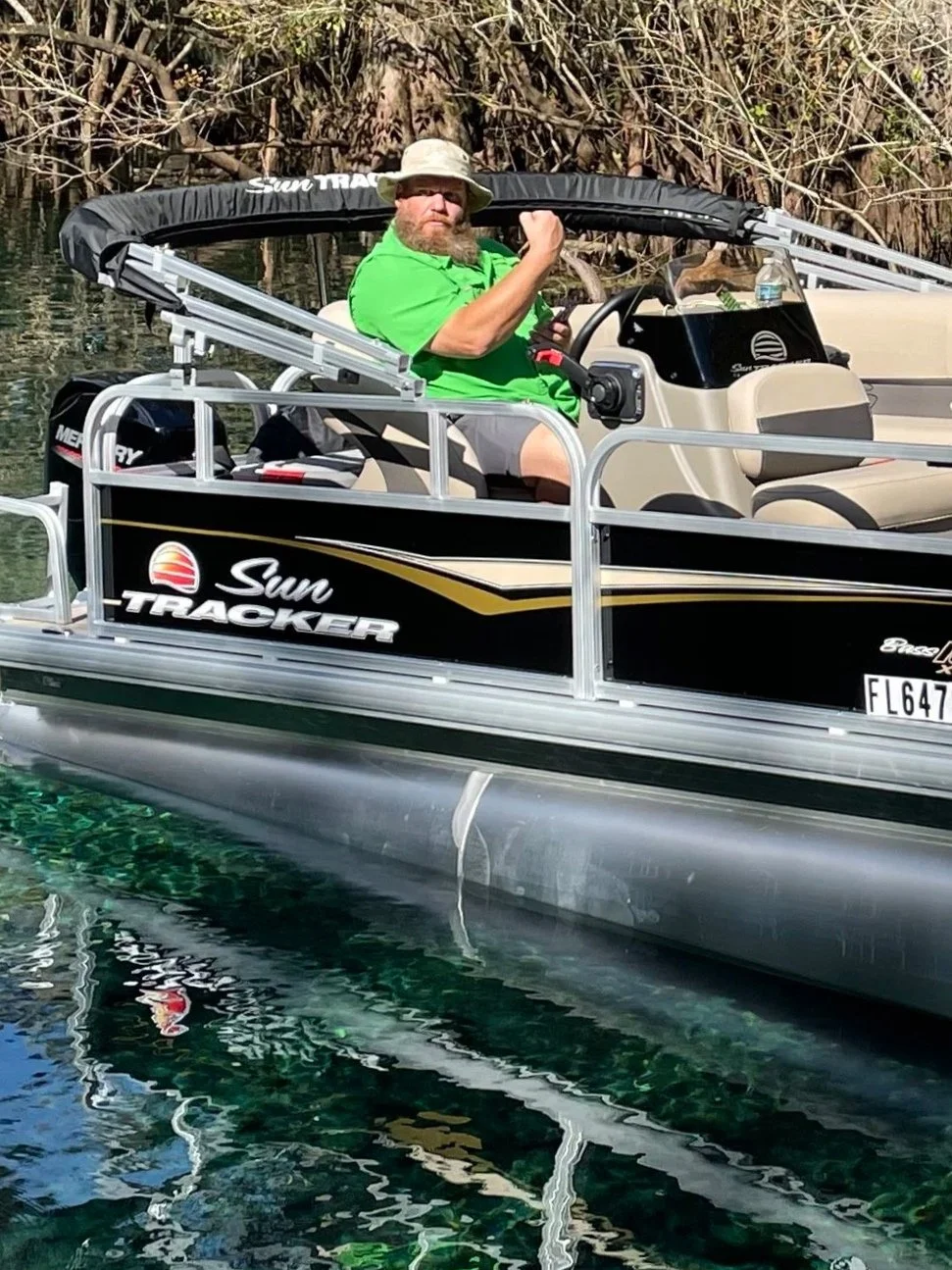 Paul sitting in the captain's chair on a pontoon boat parked in a spring