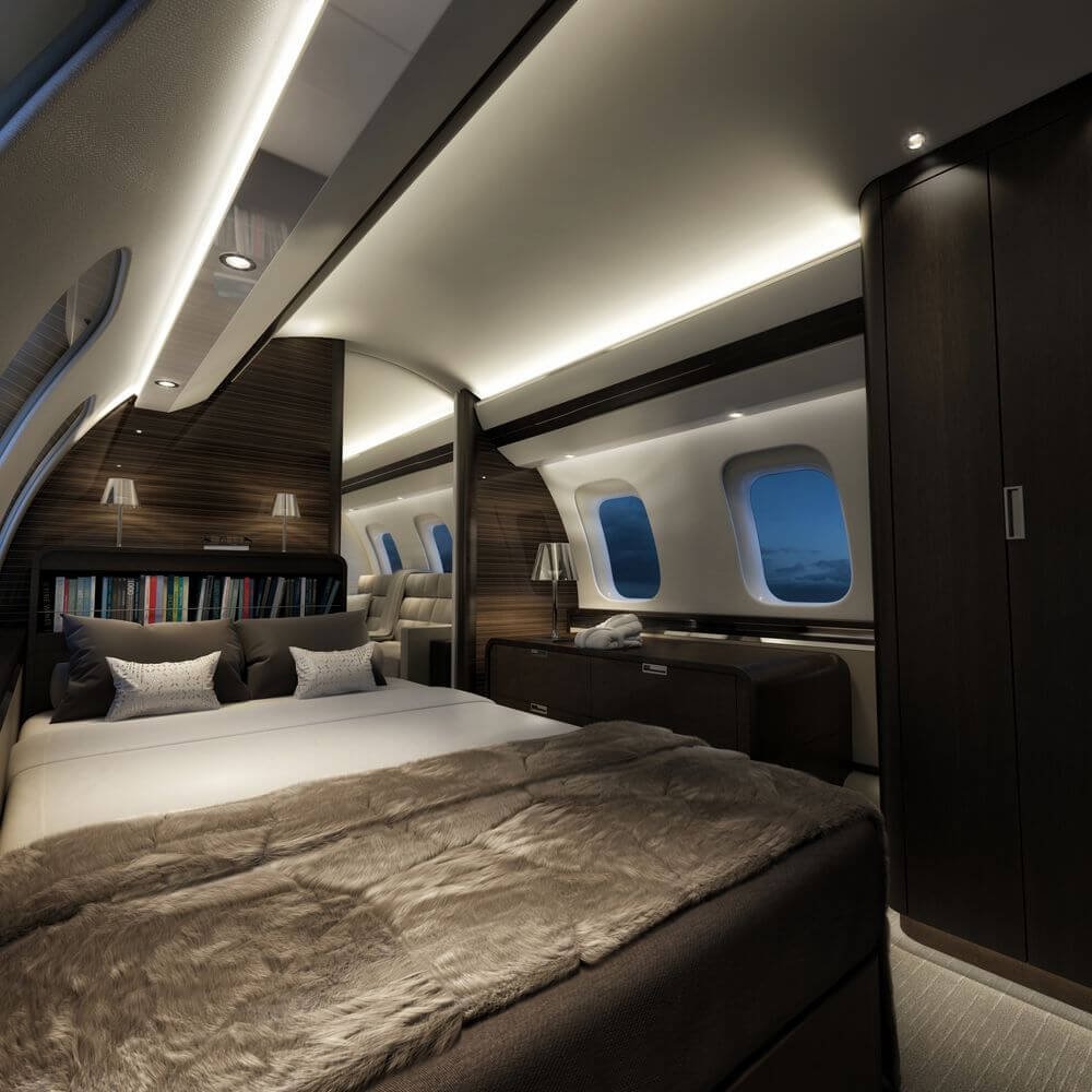 Luxurious private jet interior with a bedroom, featuring a large bed with plush pillows and a fur throw, surrounded by modern decor and soft lighting.