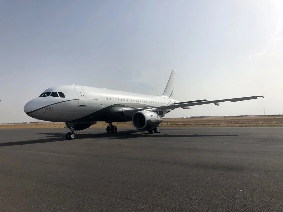 Airplane parked on a runway under a clear sky.