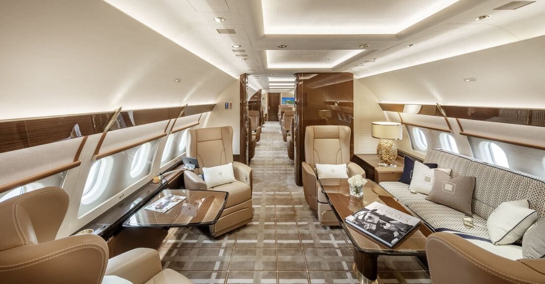 Luxurious private jet interior with leather seats, elegant decor, and ample lighting.