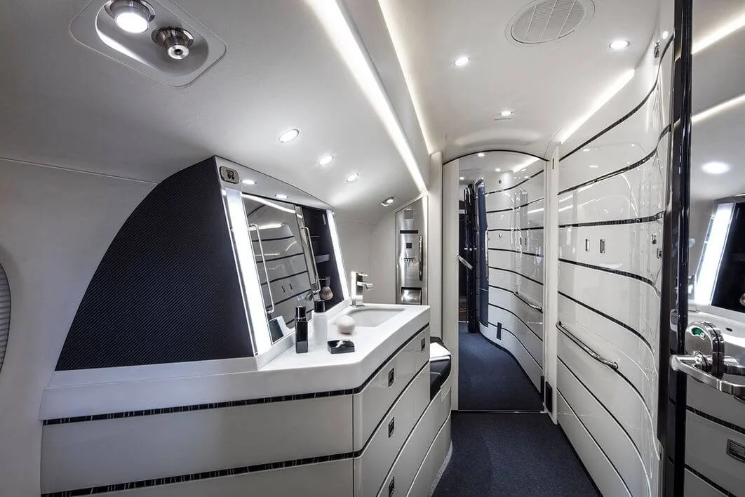 Luxurious airplane bathroom with modern fixtures, sleek design, illuminated mirrors, and ambient lighting.