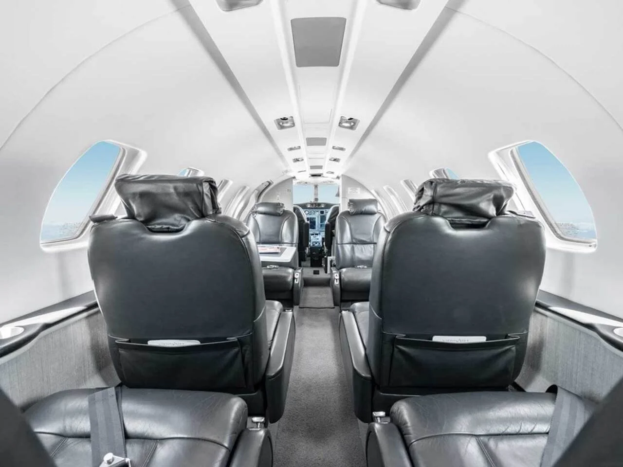 Interior of a Cessna Citation CJ2 with leather seats and several windows.