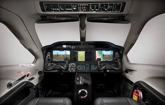 Cockpit of a modern aircraft showing multiple control panels and digital displays of Daher TBM 940