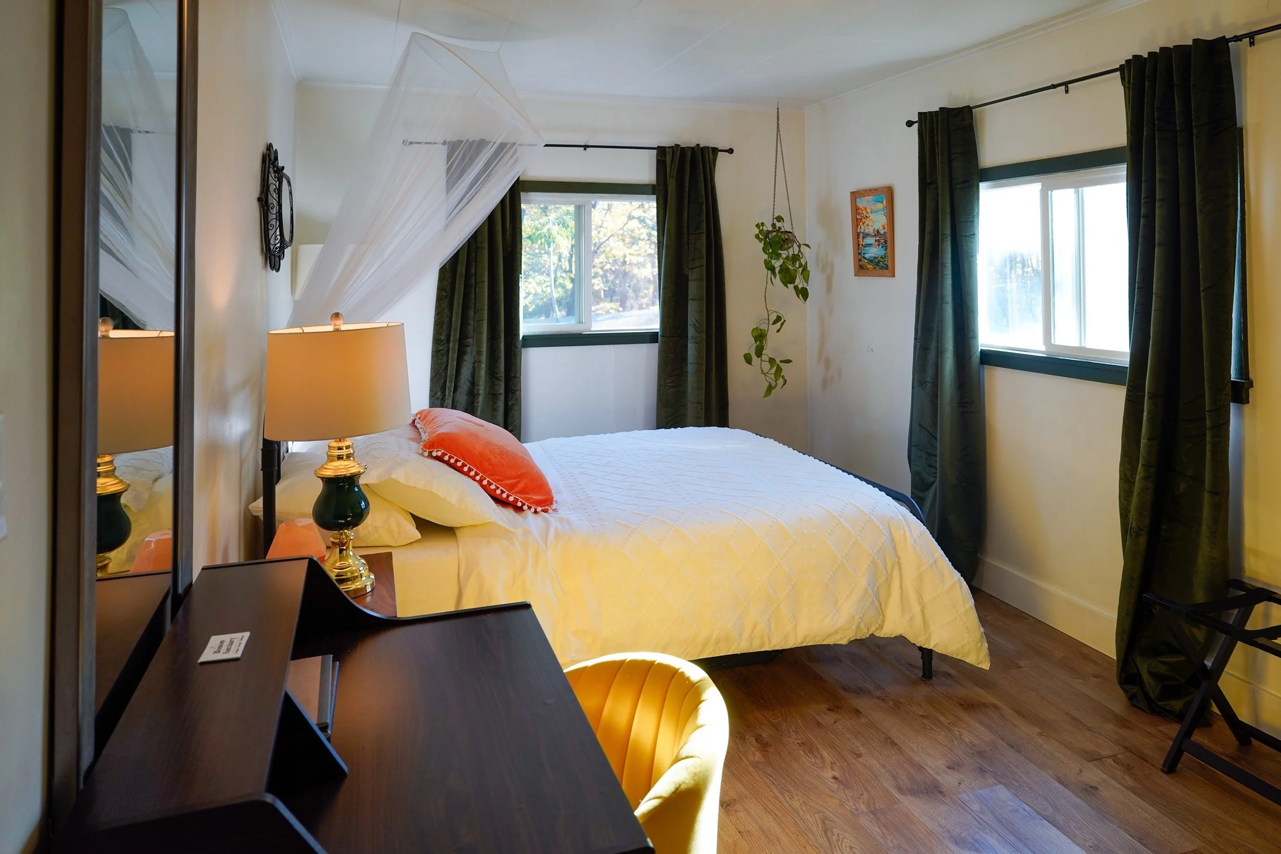 Writing desk by the windows in the queen bedroom at Blossom Sanctuary, looking out at the oaks