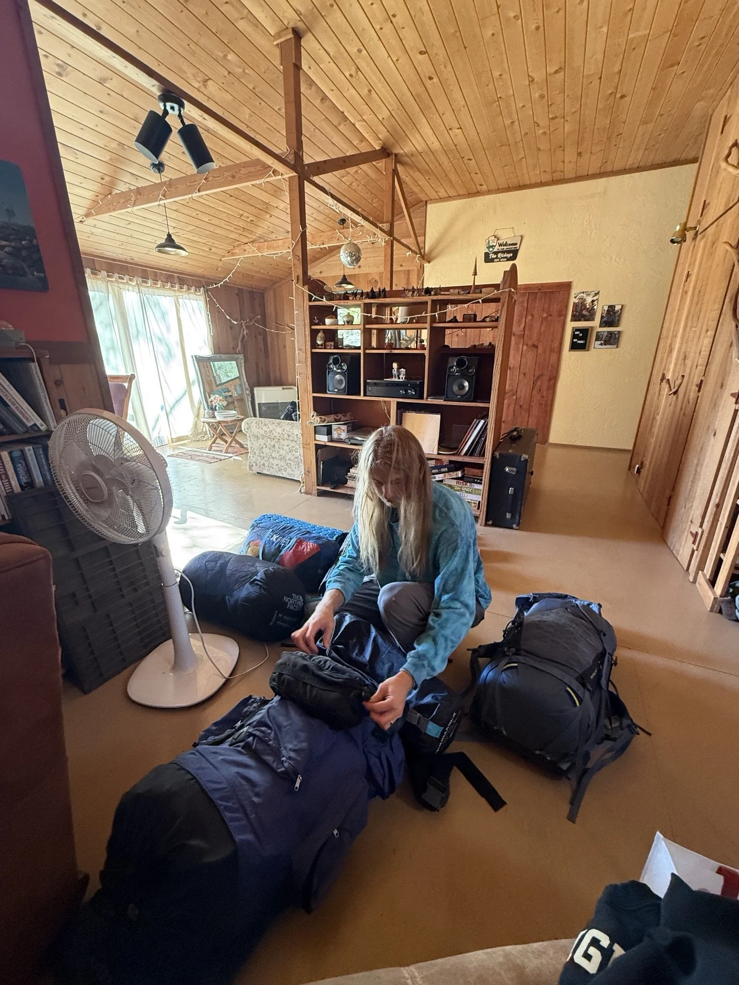 Packing sleeping bags and backpacks on the living room floor before the trip