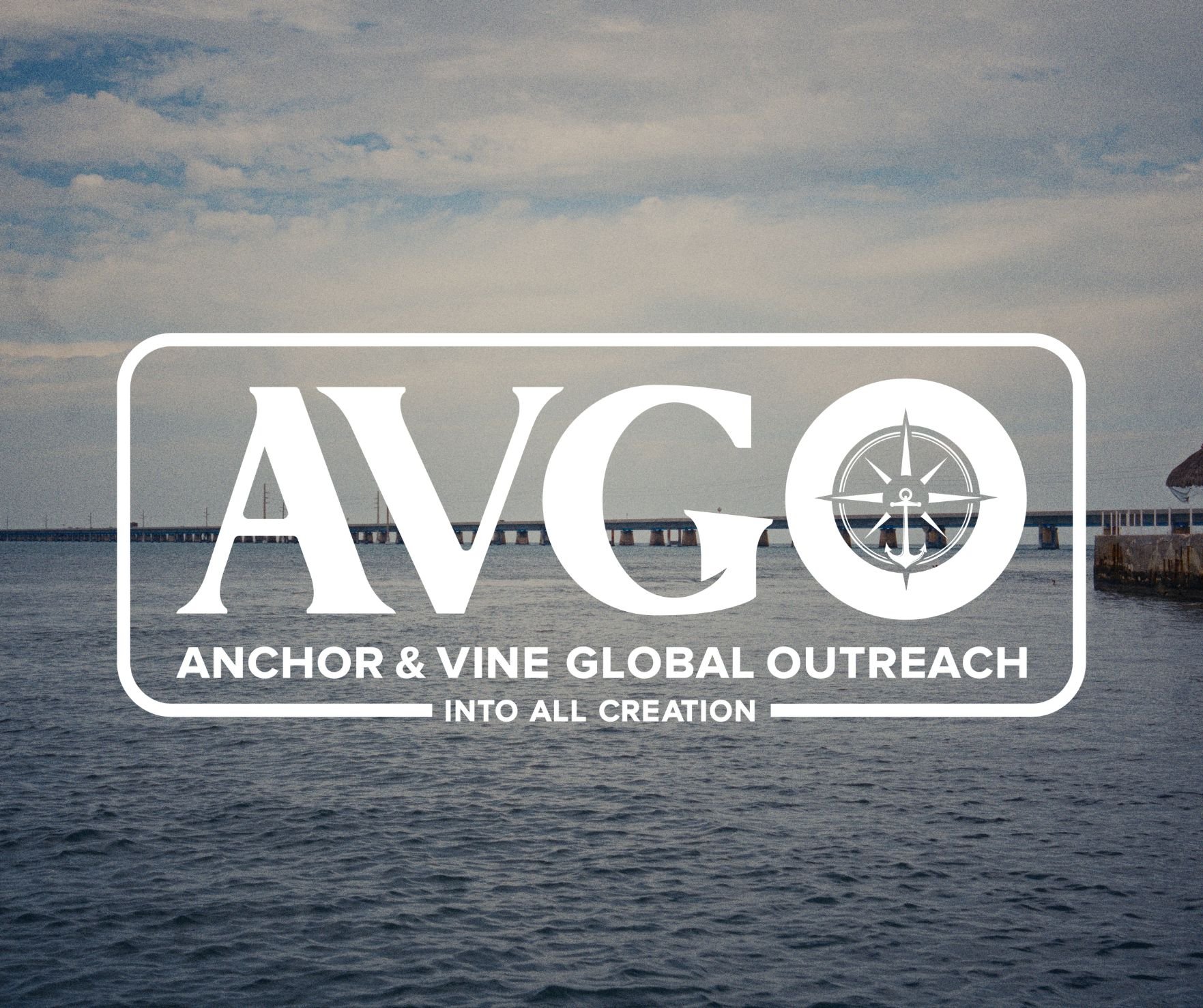 A logo for AVGO over a background of a body of water with a bridge and cloudy sky.