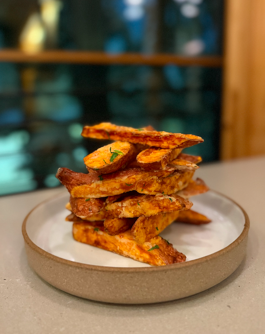 Hand cut yams with arugula aioli on handmade ceramics. World famous yam fries.