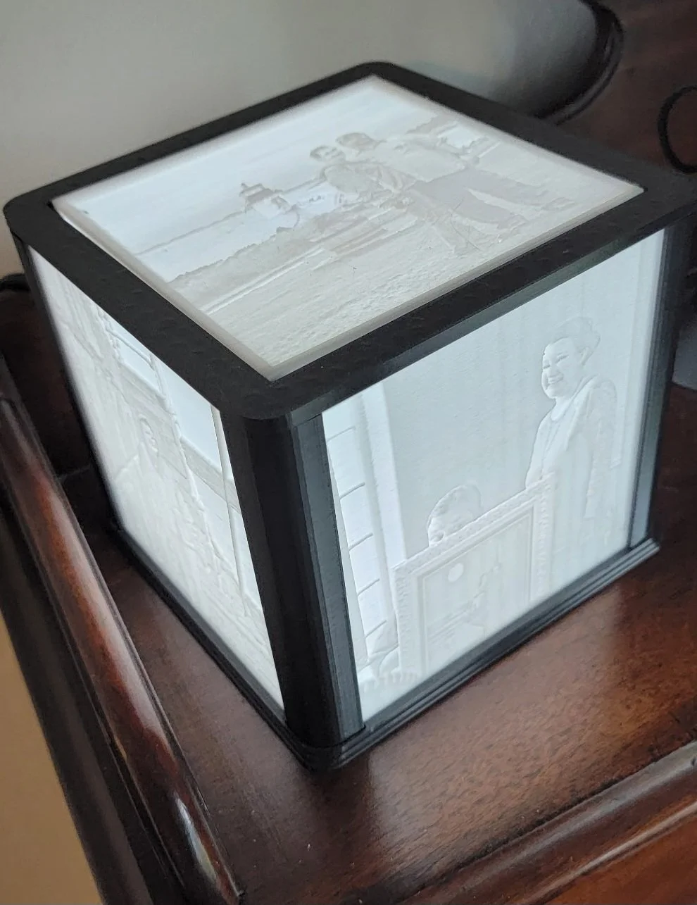 Three photograph sides are being illuminated by an LED light in a 3D printed lithophane